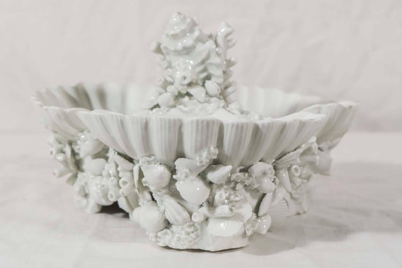 A rare 18th century Worcester porcelain shell shaped sweetmeat dish elaborately formed as three scallop shells. The shells were probably cast from actual specimens. Each scallop shell sits among a profusion of smaller sea shells and seaweed. Rising