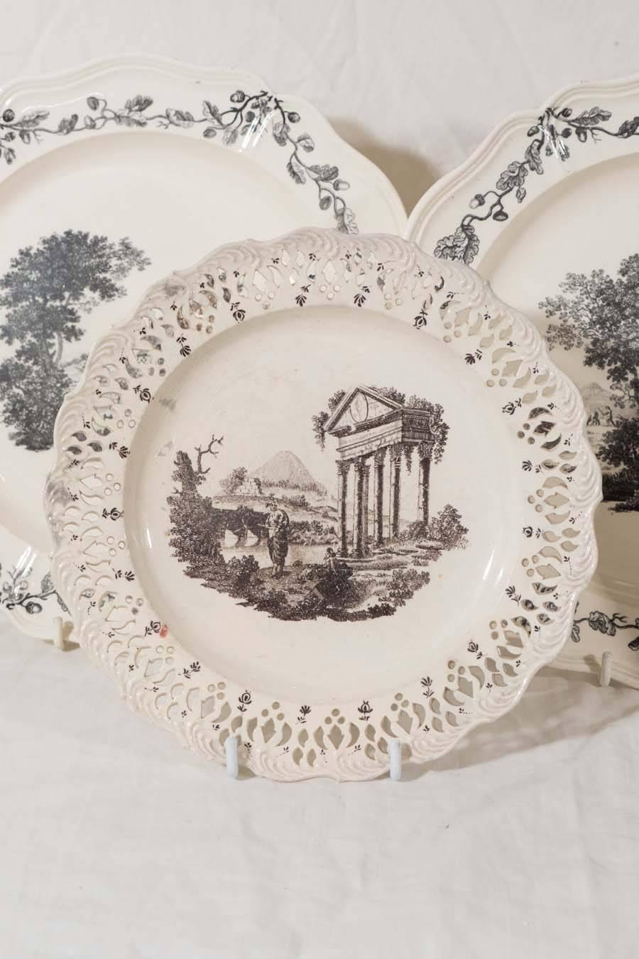 A group of five Wedgwood 18th century creamware dishes. The three larger dishes each decorated with a central scene showing a landscape and a border of acorns and oak leaves. The rustic scenes depict rural life showing fishing and farming. Printed