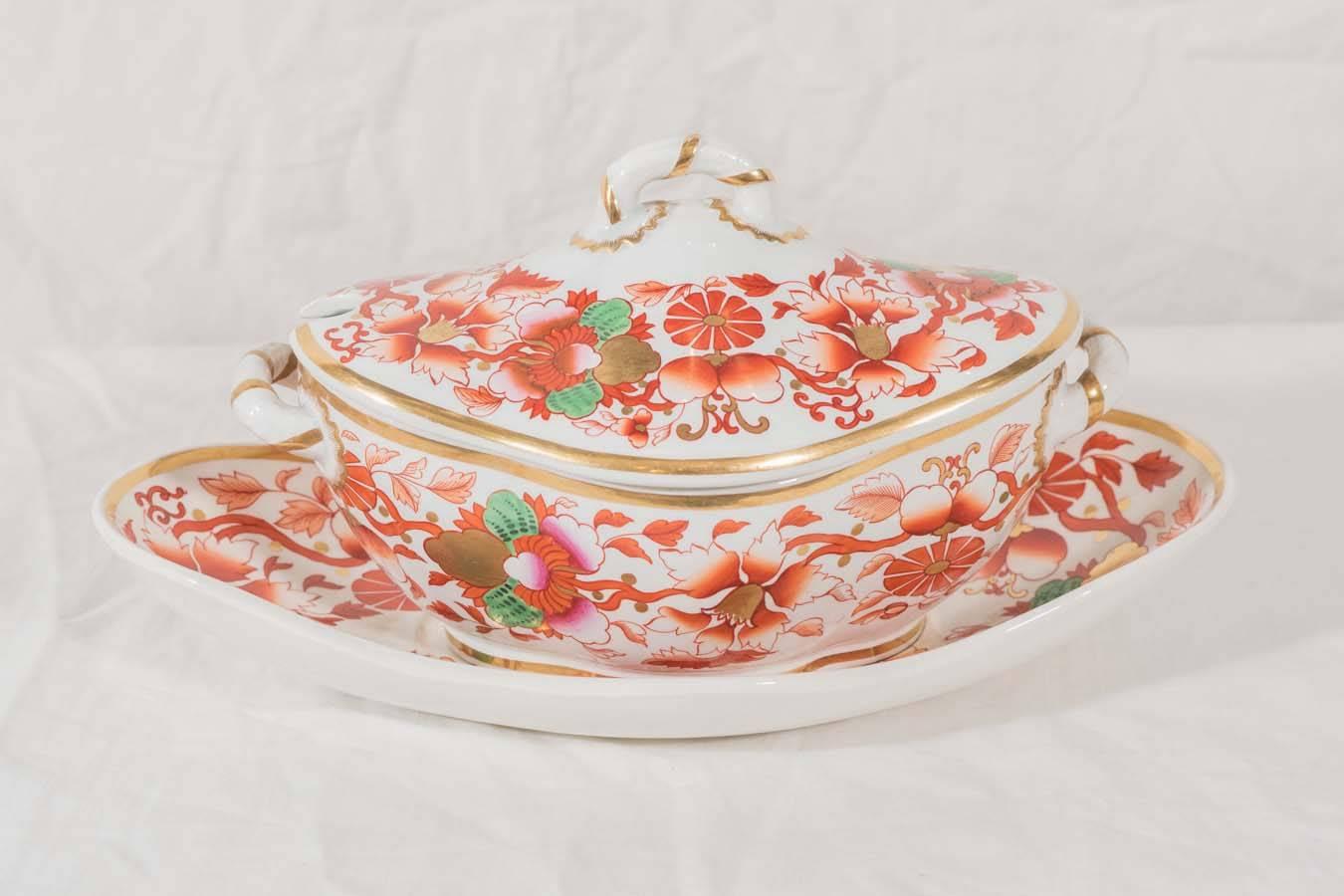 A pair of brilliantly colored sauce tureens and stands decorated with bright pink and orange flowers, green leaves and gilt. The exceptional gilding enhances the the rich colors of the flowers. The combination of colors is inspired by Japanese