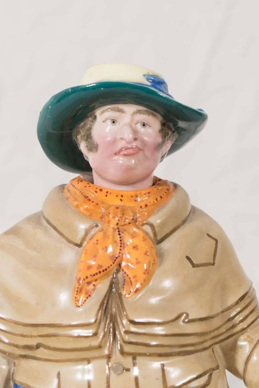 Nodding head figurine of a Victorian London coachman. He wears the overcoat and large rain hat typical of his trade. With a slight frown on his face he holds his hand out with a few coins in his palm he nods his head 