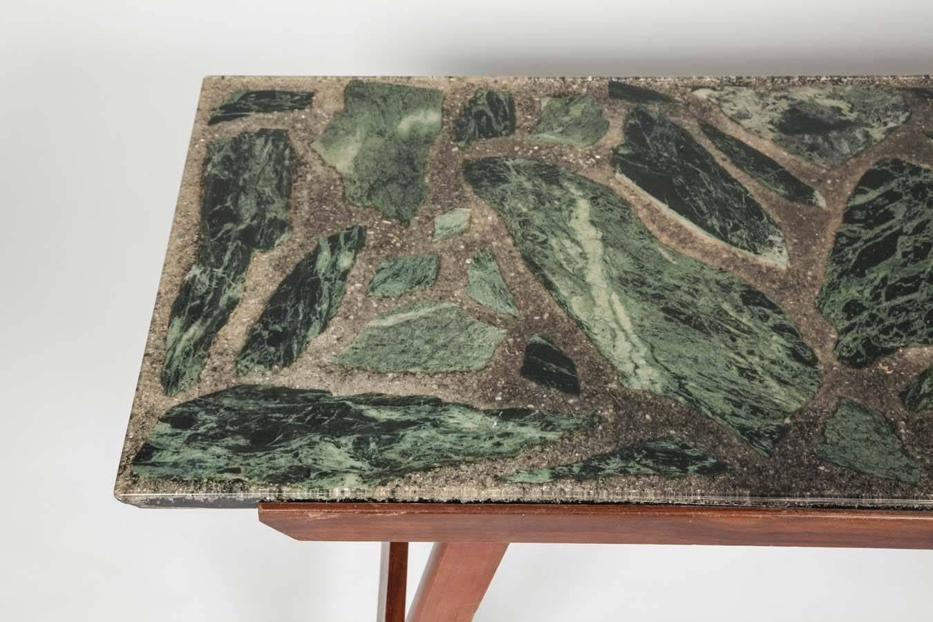 With its clean lines and elegant Silhouette this long coffee table features a striking top made of pieces of green marble set in resin. 

  