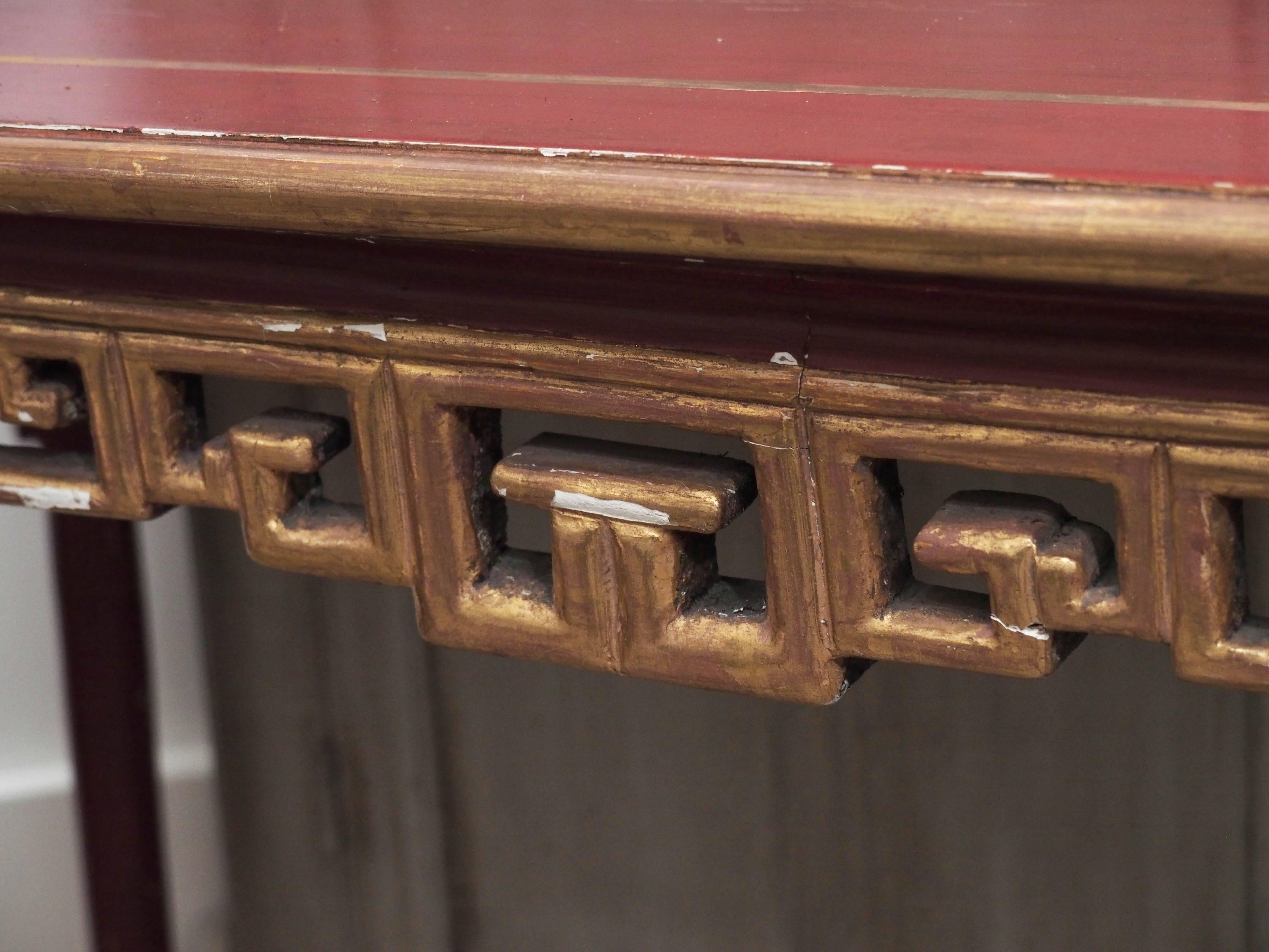 Carved wood French chinoiserie red lacquer console with gold detail.