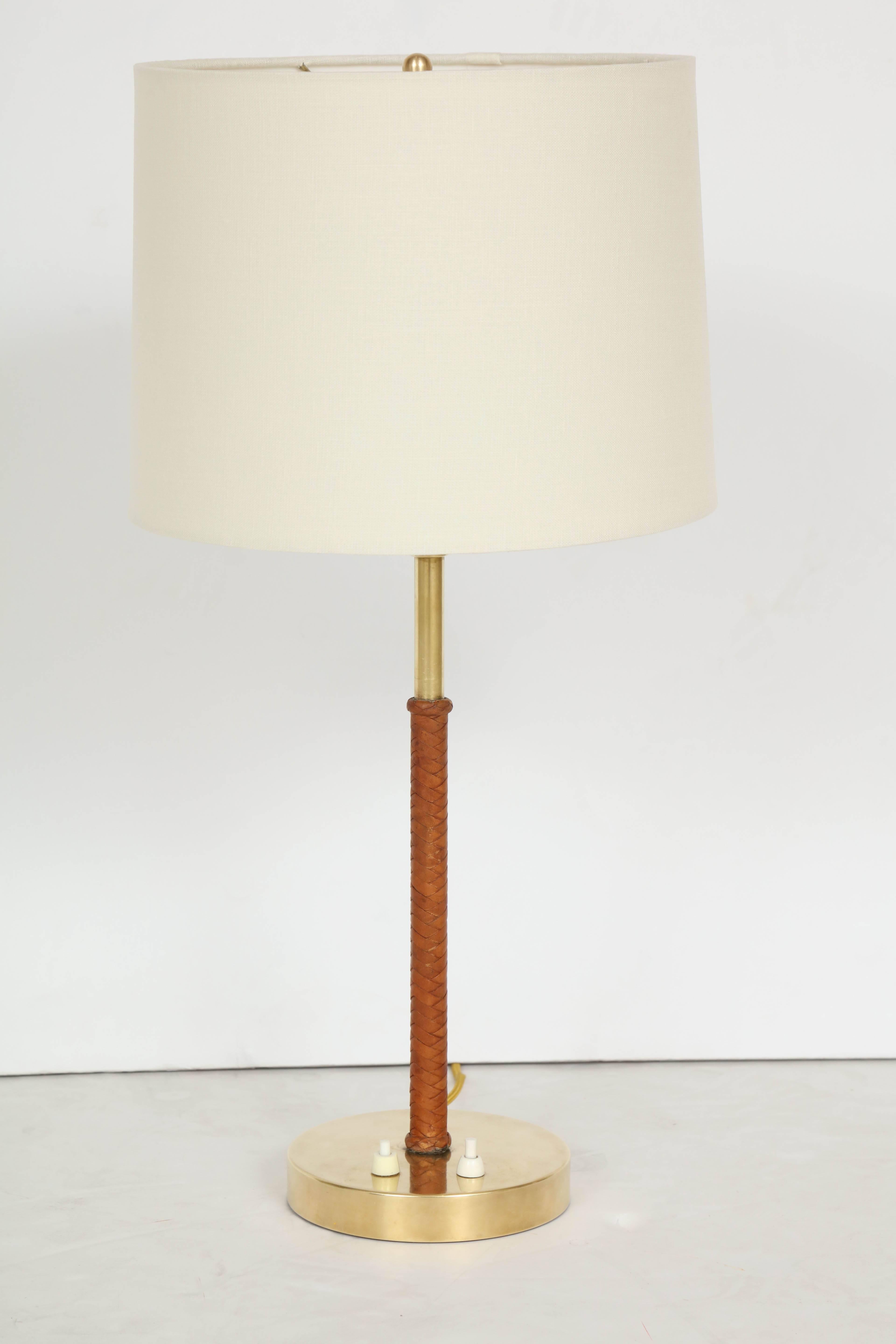 NK- Nordiska Kompaniet Table Lamp, Sweden 1940s, Brass a leather woven wrap stem with a new linen shade. Two base switches, one for three down lights and one up light. Restored including re-wiring for US.

Stamped on base.