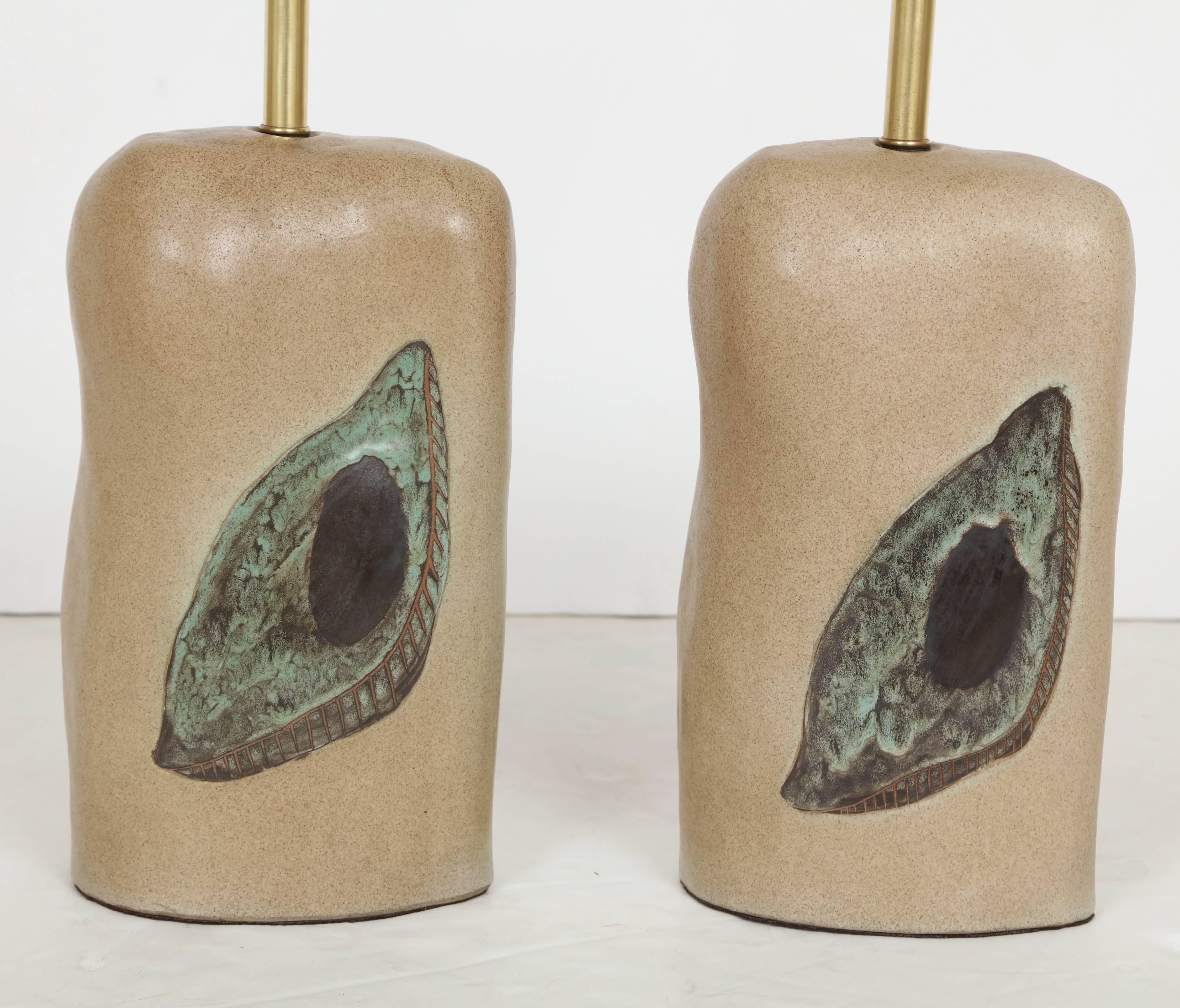 A very fine pair of lamps by New York art ceramicist Marianna von Allesch (Germany/American 1886-1972). Biomorphic redware oval cylinder bases are glazed in a a satin limestone-like glaze and incised and hand-painted with an abstract design in