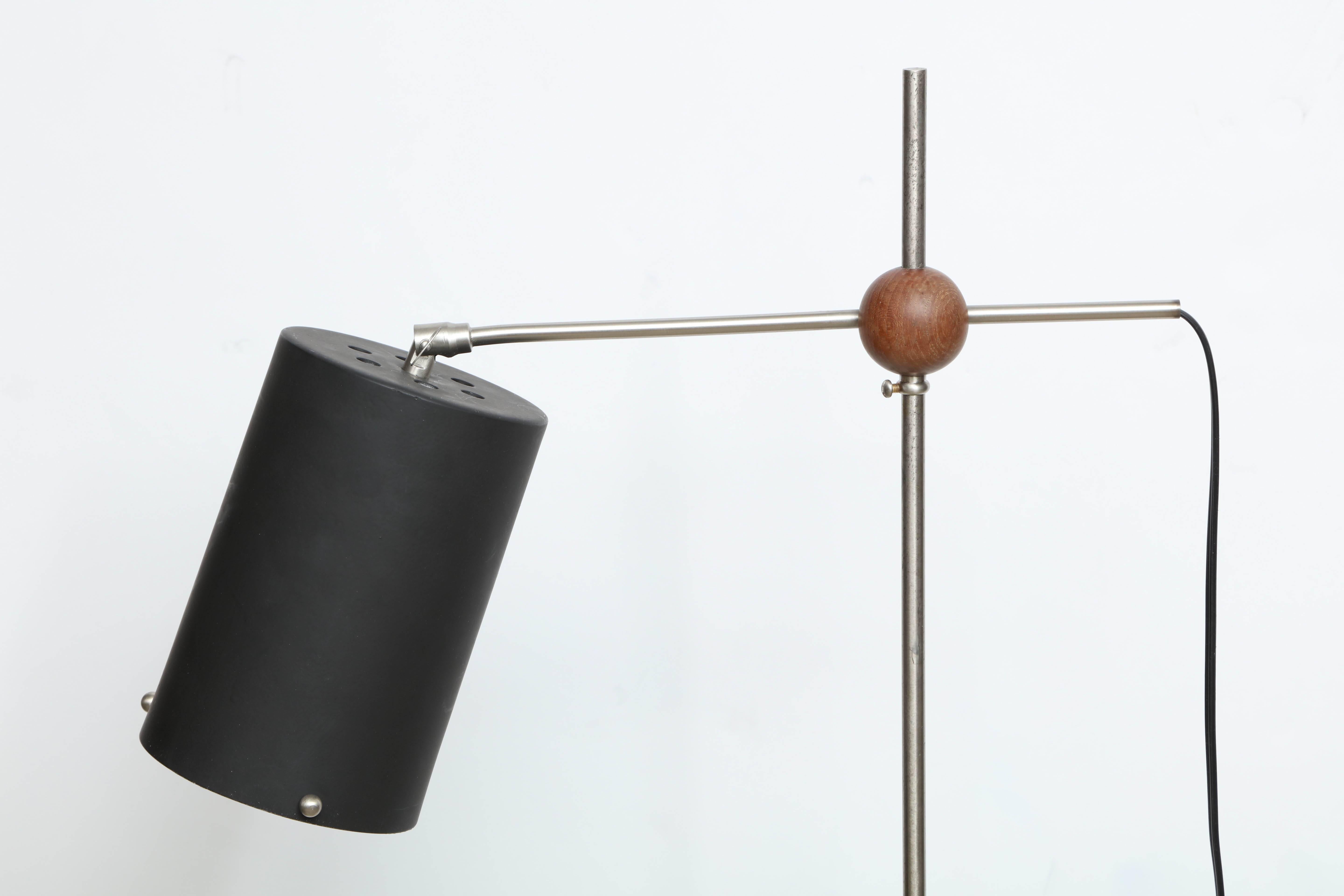 A cast iron cylinder supports a dull nickel rod piercing a teak sphere which connects a nickel cross-bar to a painted aluminium cylinder shade and permits adjustment to any height, Finnish, 1950s. Newly rewired for US usage and repainted to original