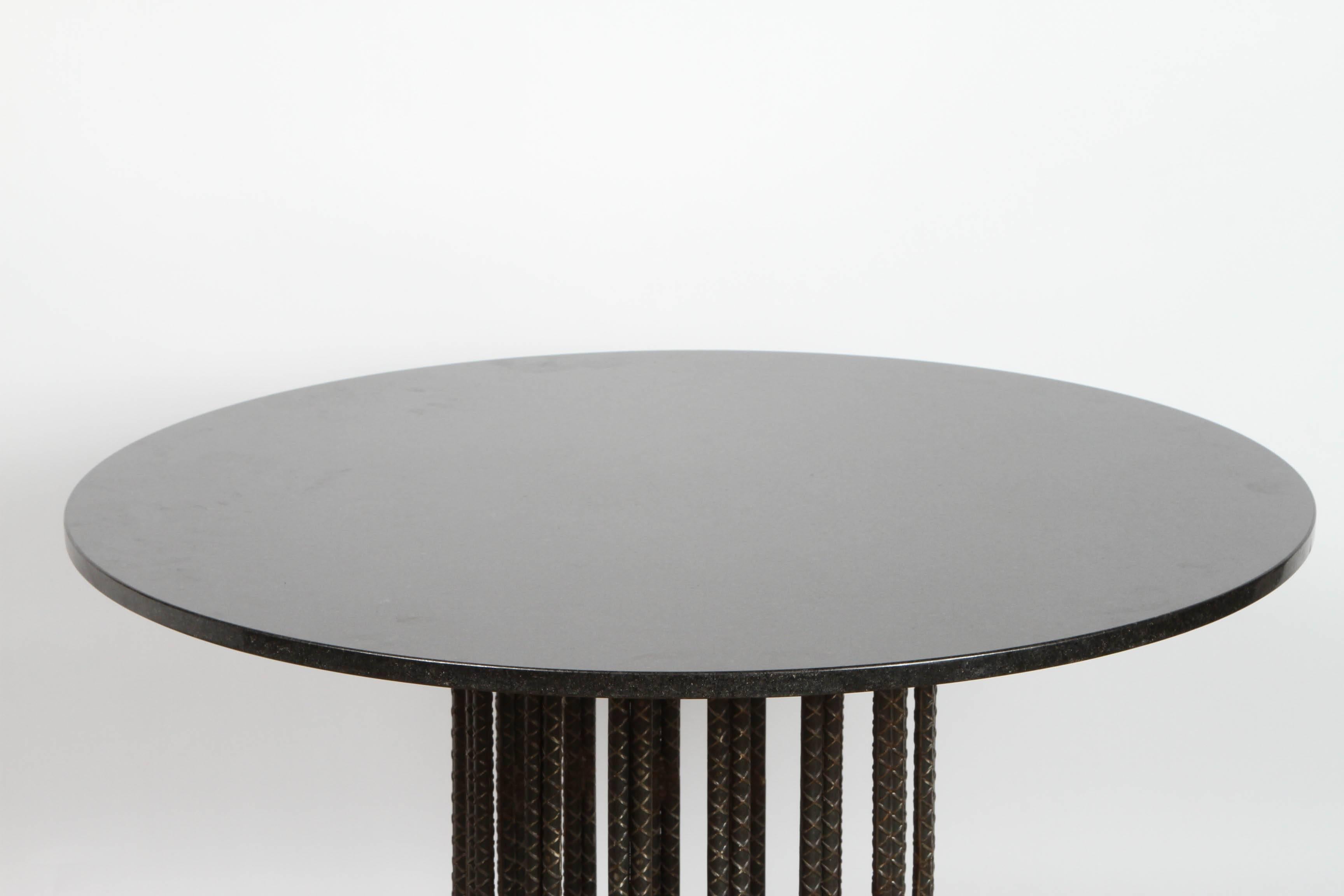 Formed from multiple loops of rebar this circular table supports and round granite top. Unsigned.