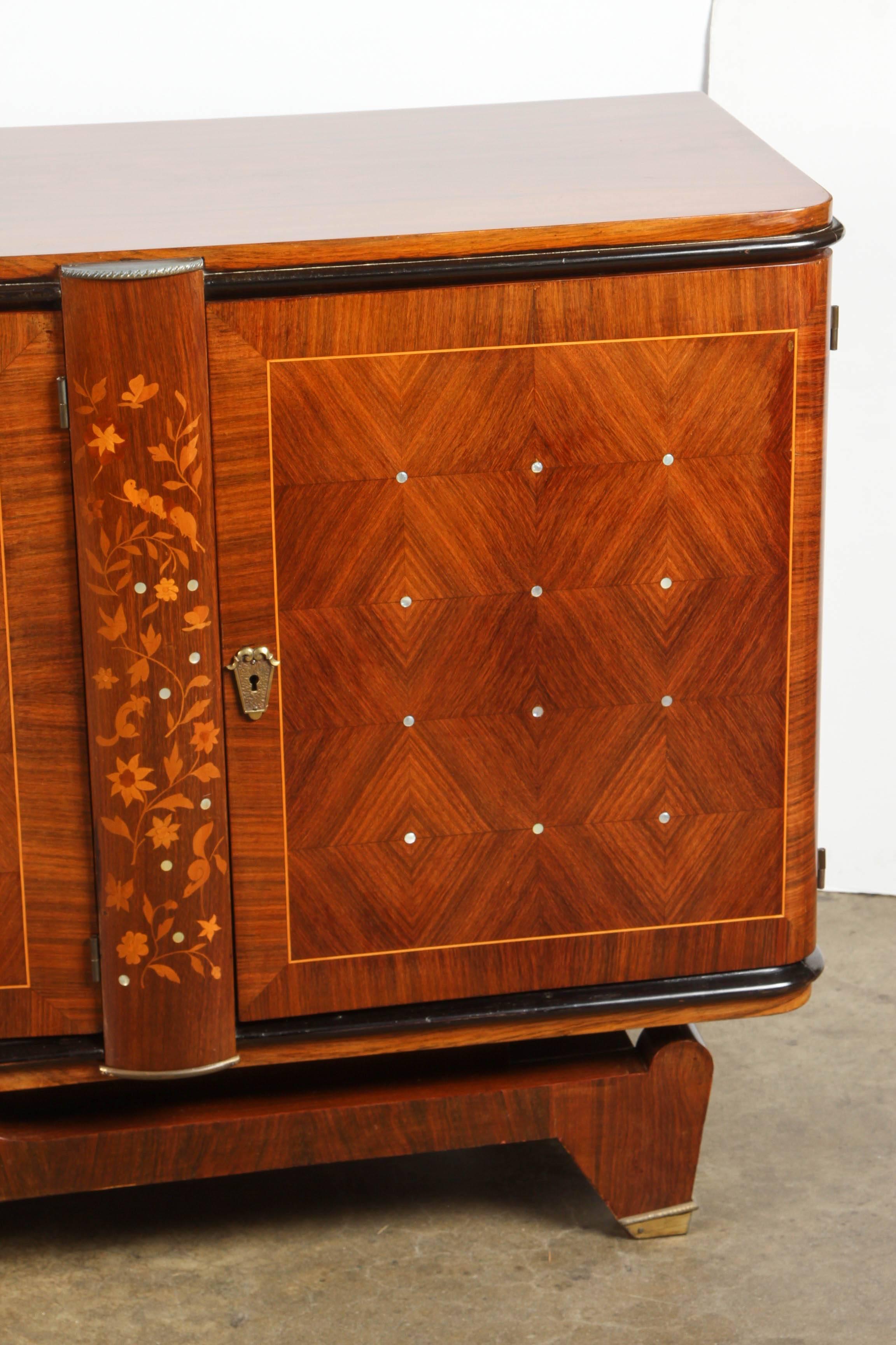 In the style of Andre Leleu the sideboard is done in a marquetry and inlaid over all.