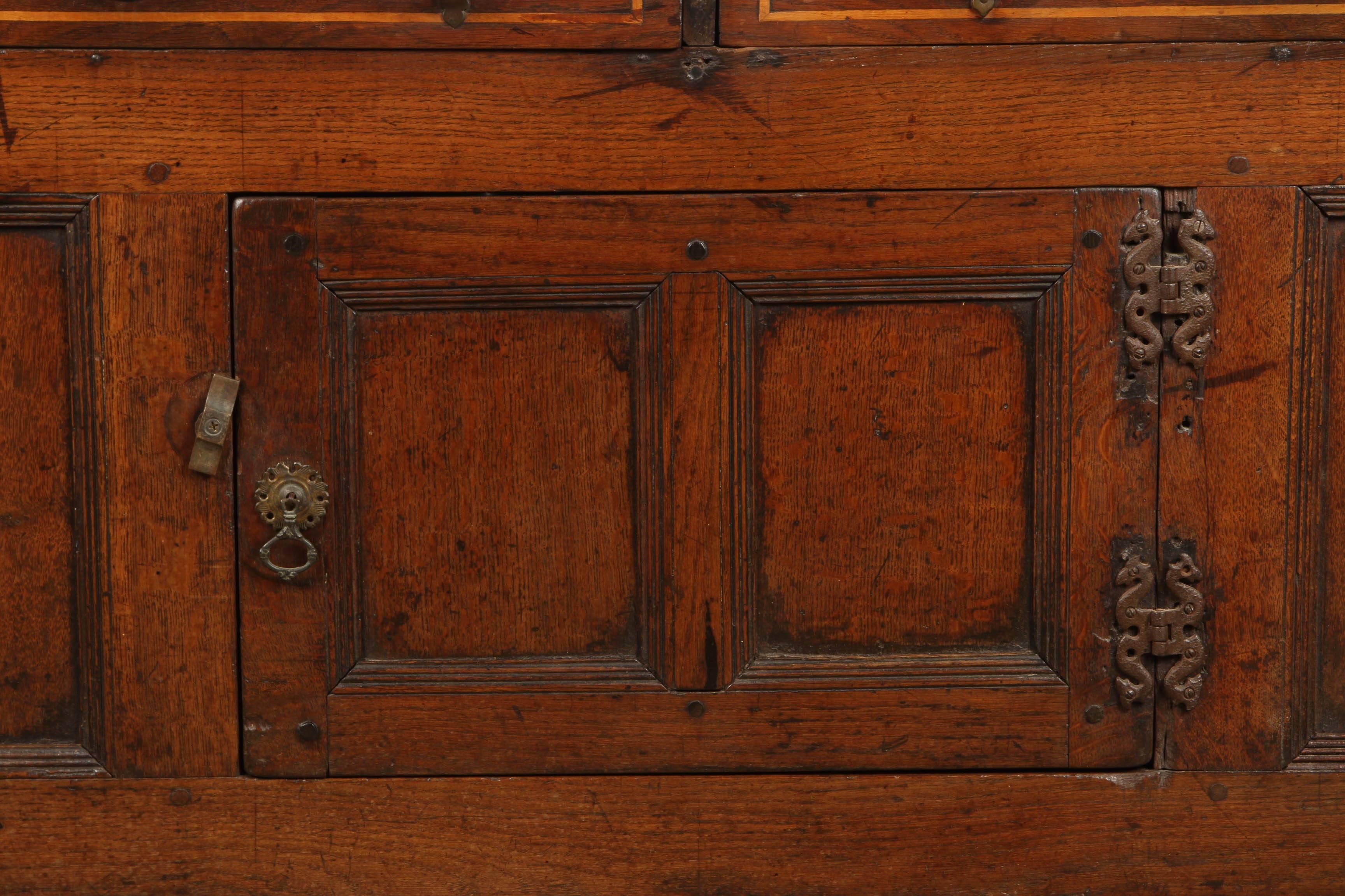 Well figured and with a nice patina, this English oak sideboard has two banded inlaid drawers over a single pair of doors.