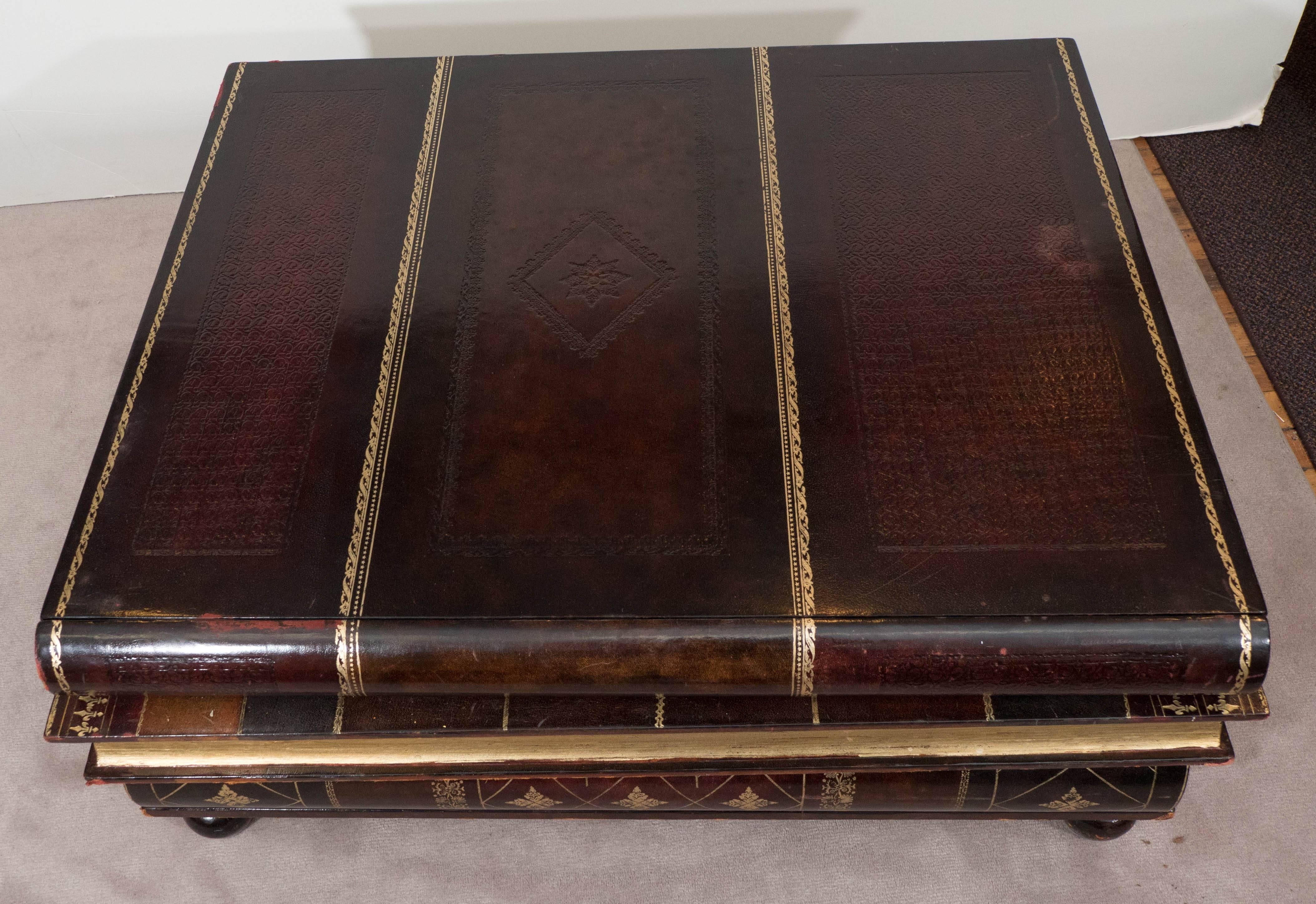 A coffee table by Maitland-Smith, produced circa 1980s-1990s, designed as a stack of three leather embossed and gilded books, over round feet; includes three drawers, concealed as the spine of each book, the interior lined with marbled paper.