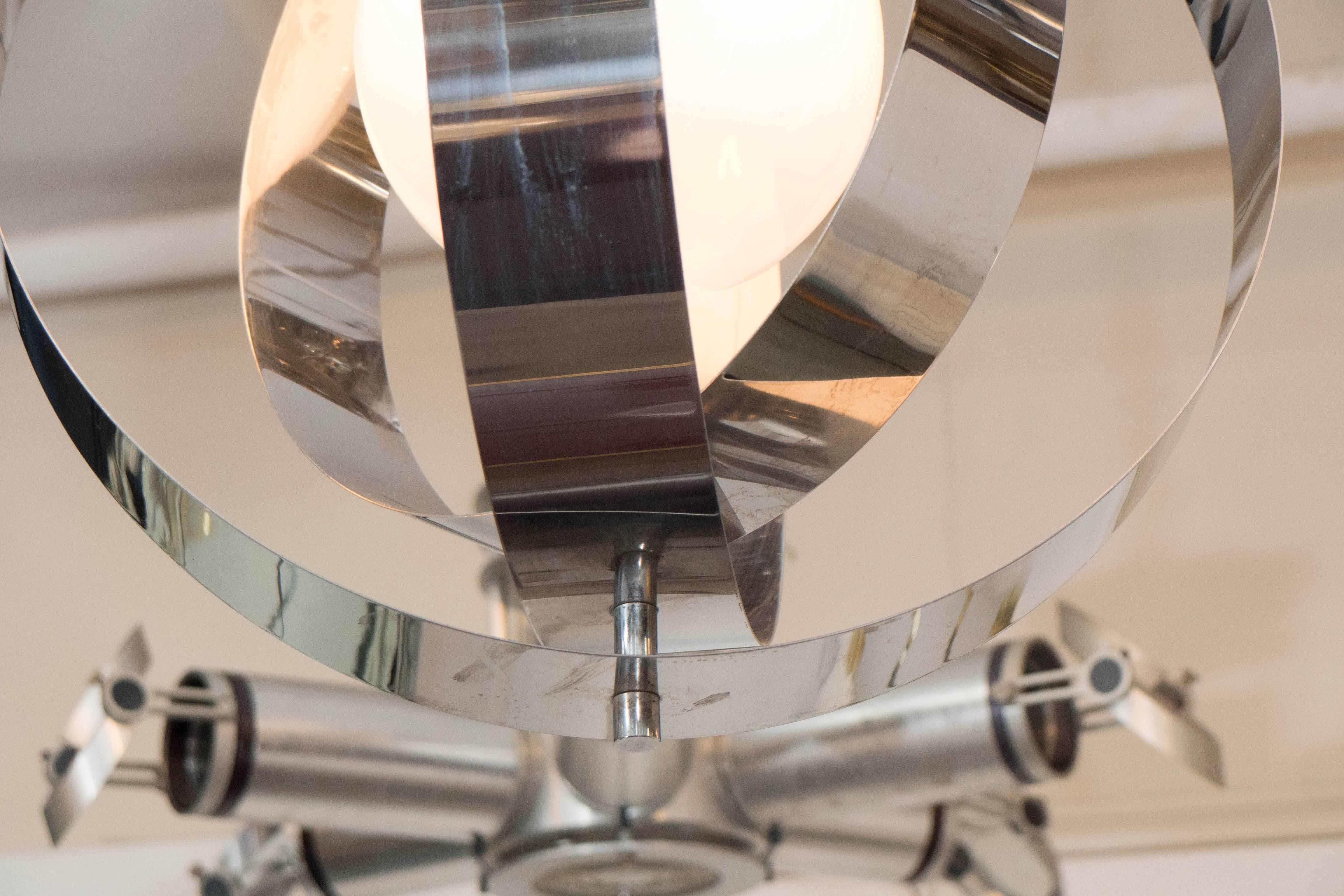 A pendant light, produced in Italy circa 1970s, which includes a frosted glass globe surrounded by three layers of polished chrome rings, creating the appearance of an armillary globe. Wiring and sockets to US standard, requires a single Edison base