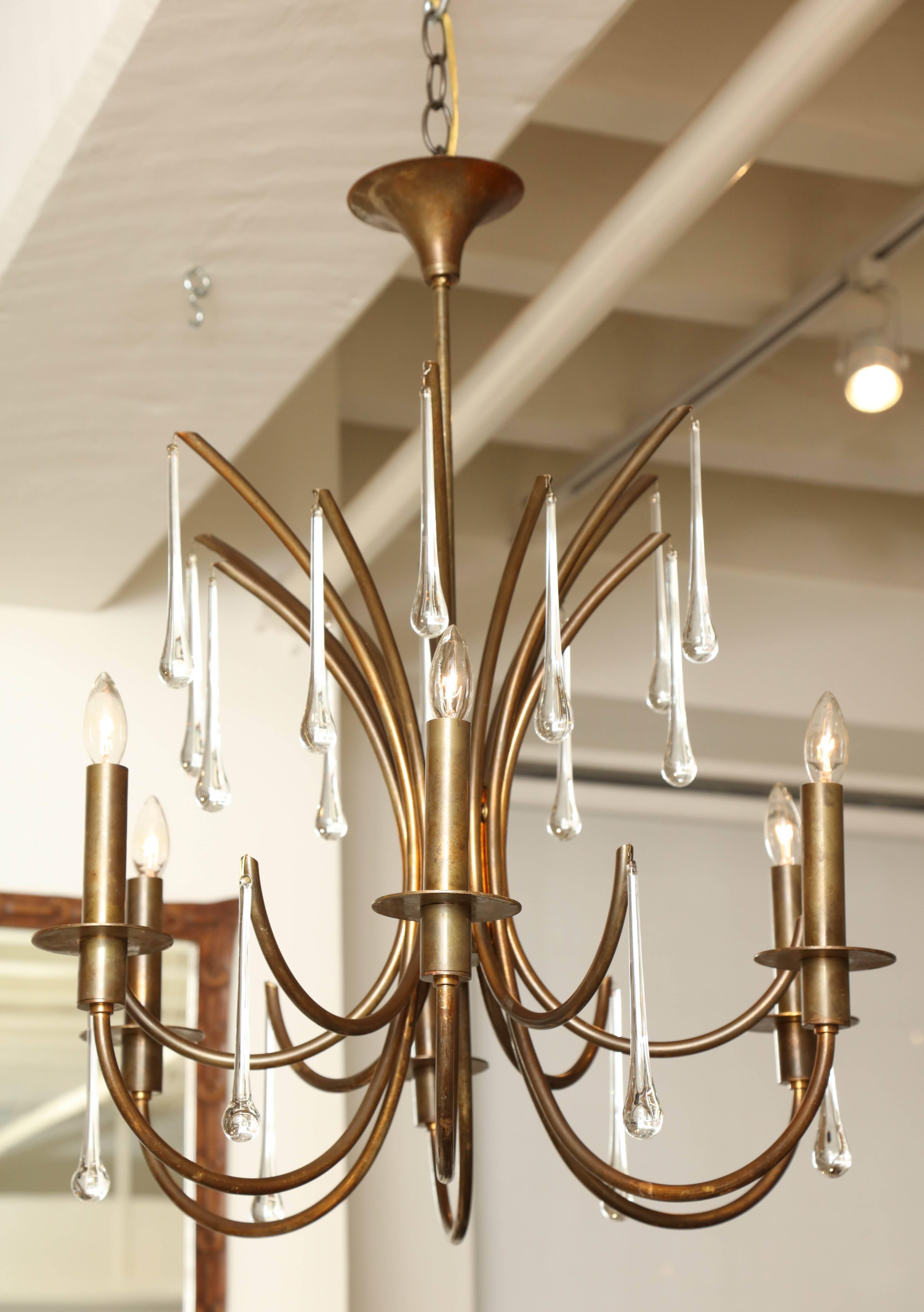 Patinated brass six-light chandelier with long crystal drops. Wired for US specifications.