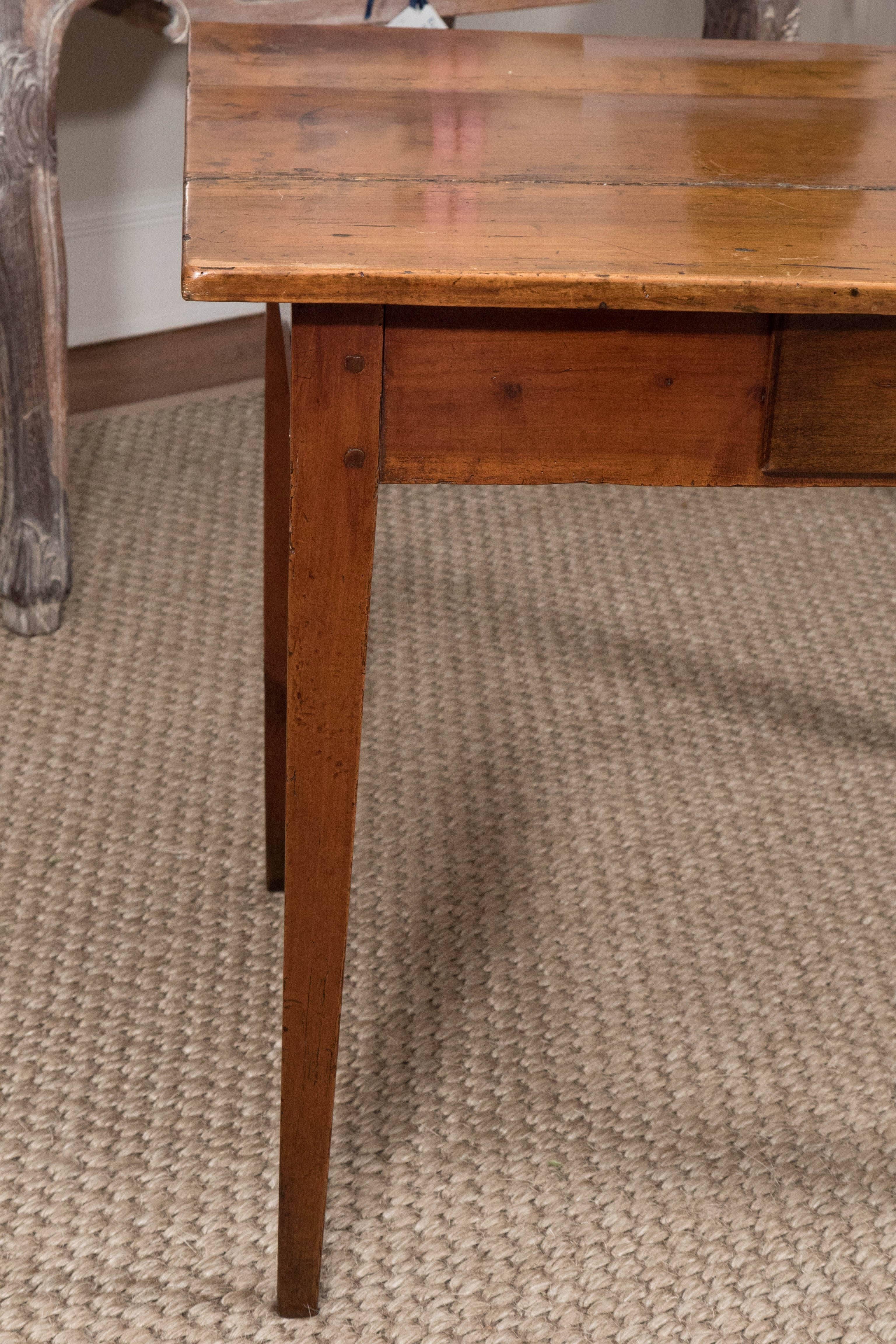 A charming French walnut side table, aged to perfection. The table, with a wonderful, warm patina, has one drawer and slightly tapered legs.