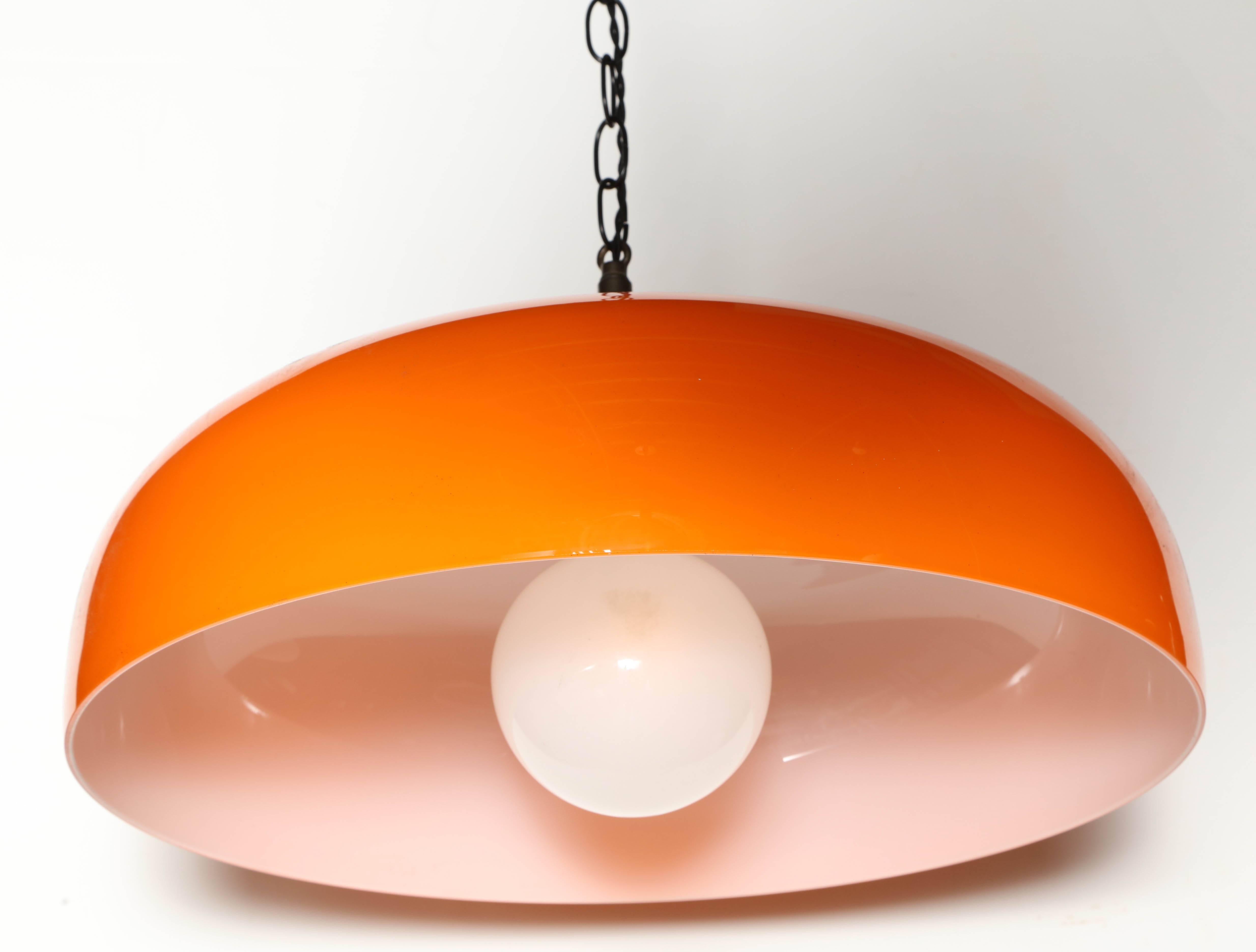 Large Italian Modern Murano Venini Lamp Co. Adjustable Hanging Lamp, circa 1950's. Featuring a large bell shaped cased glass shade with Orange exterior and White interior. Shown with Decorator bulb.  Kitchen. Casual dining. Game Room.  Made in