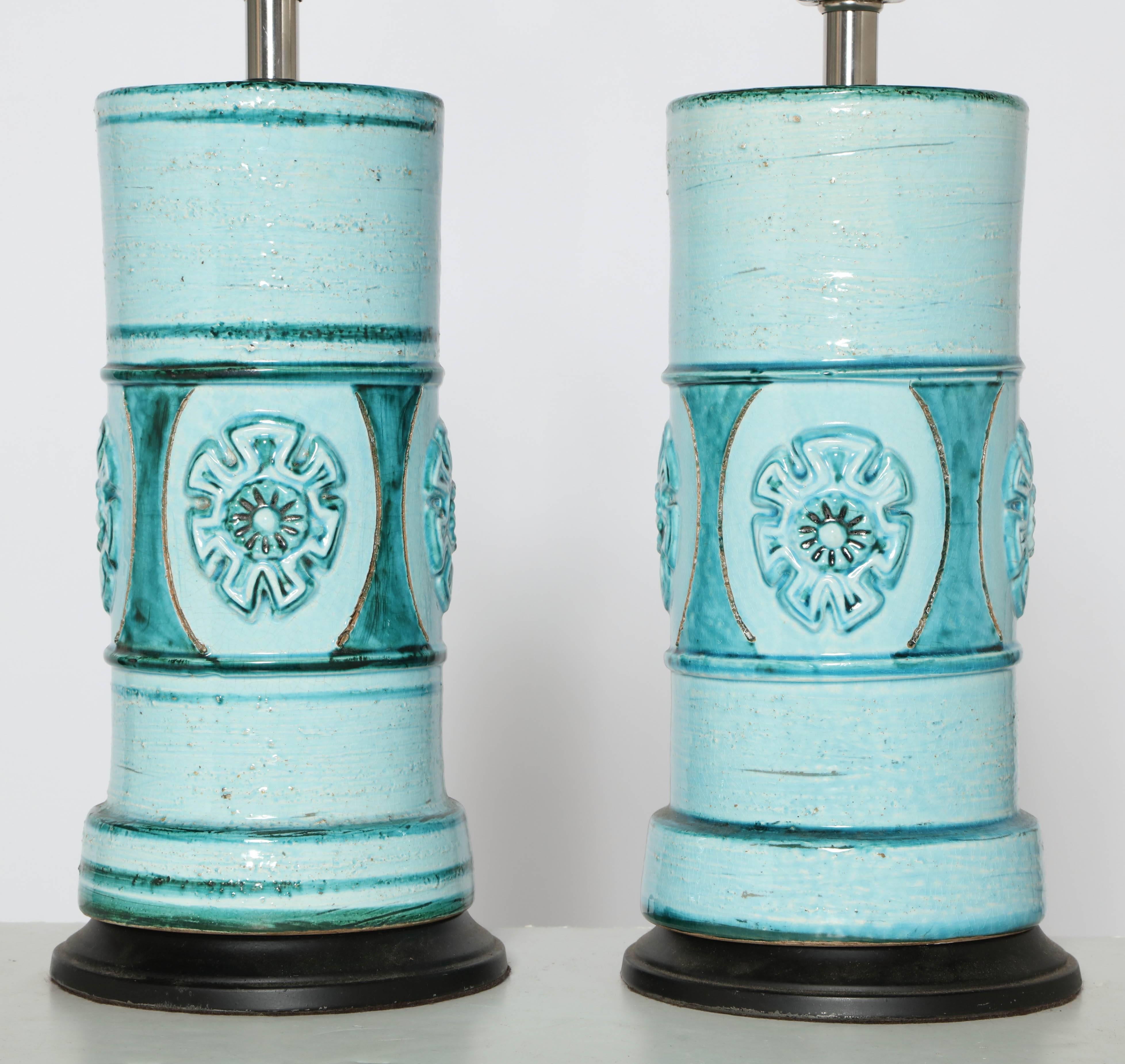 Pair of 1950s Aldo Londi for Bitossi Ocean Blue Glazed Ceramic Table Lamps.  Featuring a cylindrical form with raised floral design in Seaside shades of Turquoise, Pale Turquoise, Aqua and Light Aqua. On a round 6.5D Black enameled metal base.