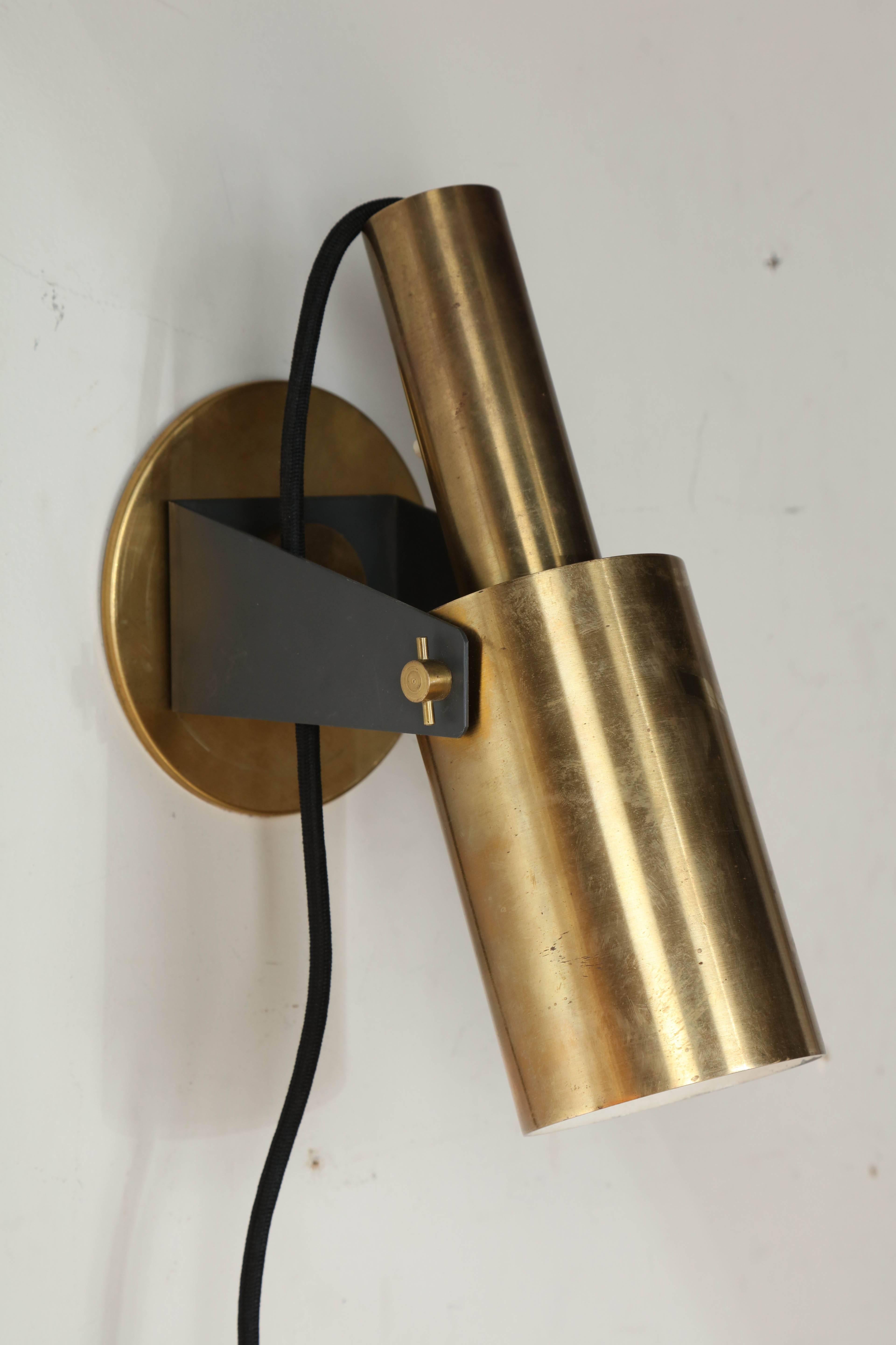 Pair of Slender Italian Mid Century Modern Brass Wall Sconces from the 1960's.  Featuring nicely machined, Industrial style, cylindrical and adjustable Brass shades with Off-White interior, Brass swivel bracket and round Brass wall support. Provides