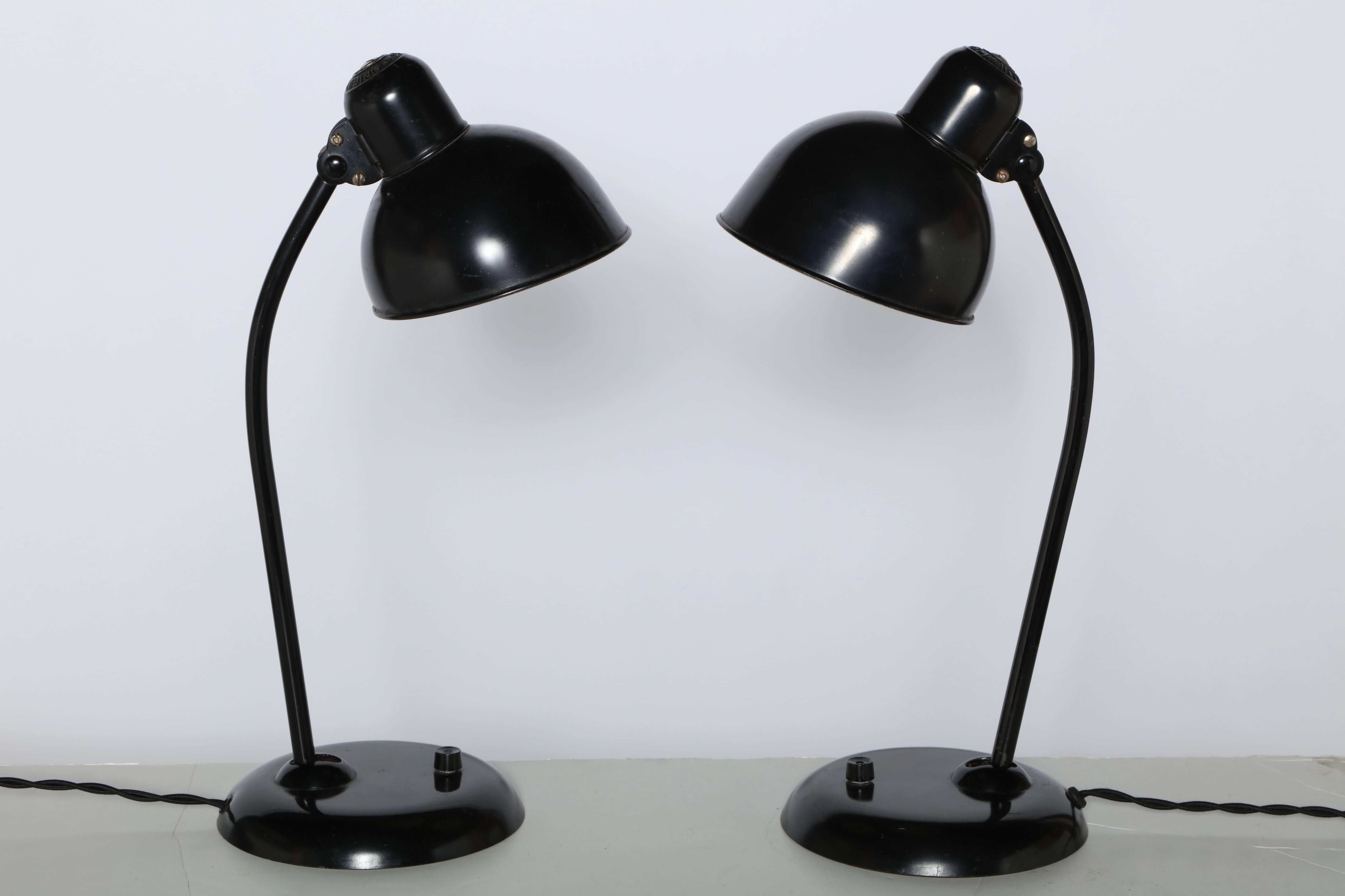 Pair of early version All Black Christian Dell for Kaiser Idell 6556 adjustable Table Lamps. Featuring adjustable 6D Black  enameled metal Shade, arm and base with Off-White Interior. Round 7.5D knuckle base. Base switch. Original condition. Made in