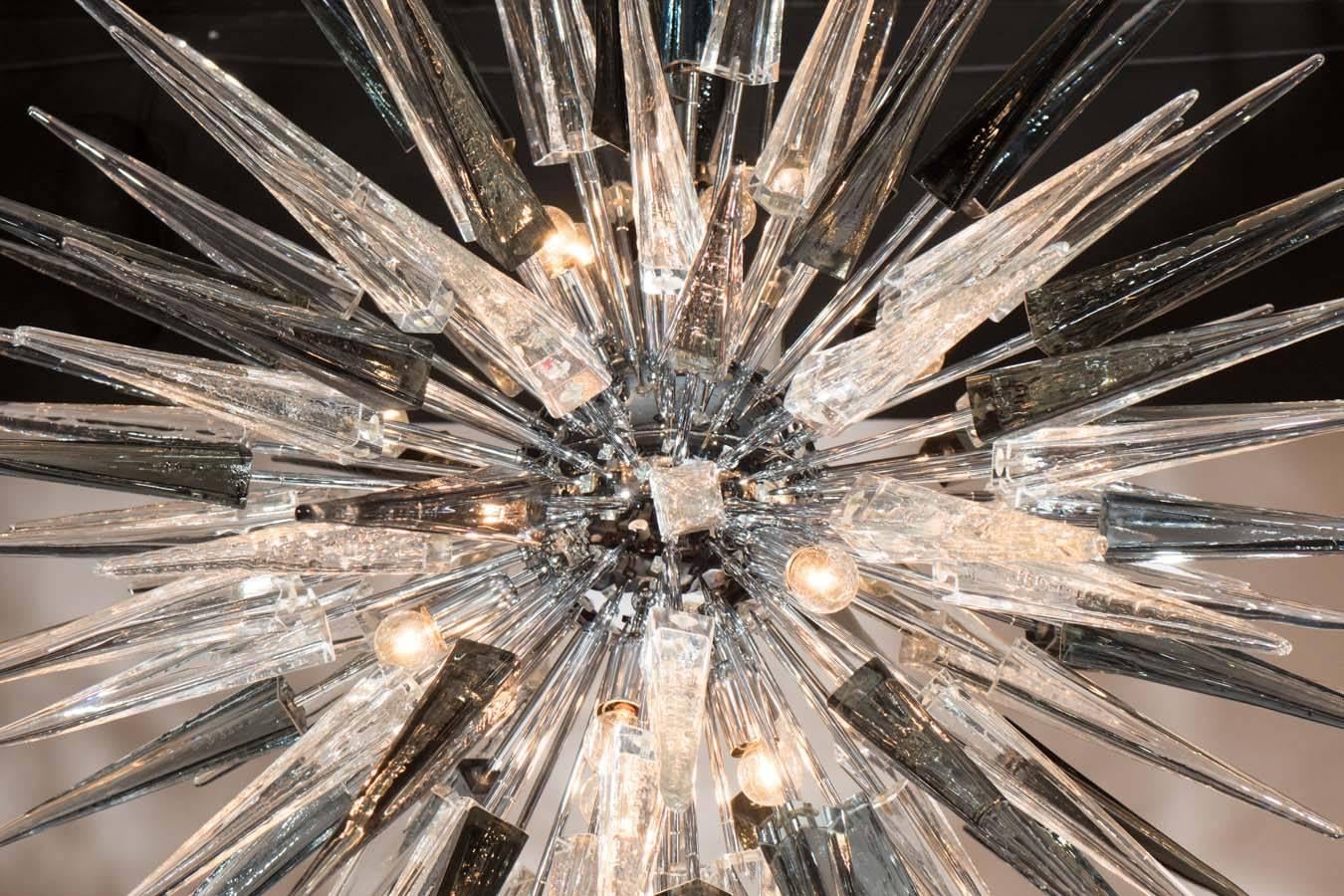 This stunning modernist Sputnik chandelier was realized in Murano, Italy- the island off the coast of Venice renowned for centuries for its superlative glass production. It features a polished nickel spherical center surrounded by handblown Murano