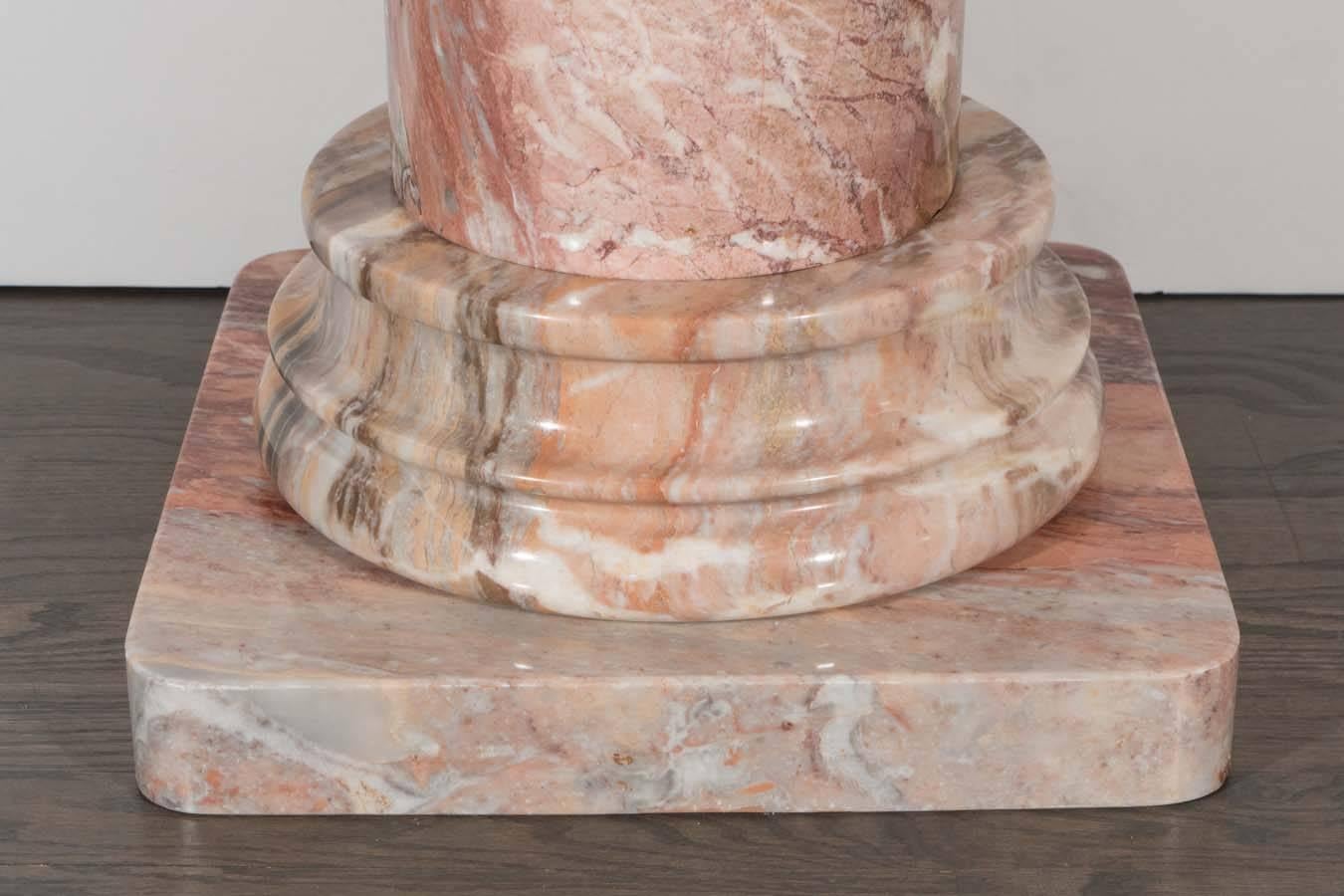 A Mid-Century exotic Italian rose marble Doric-style column pedestal. A polished cylindrical base is supported by a round-edged square base and top. This piece is in excellent condition.
