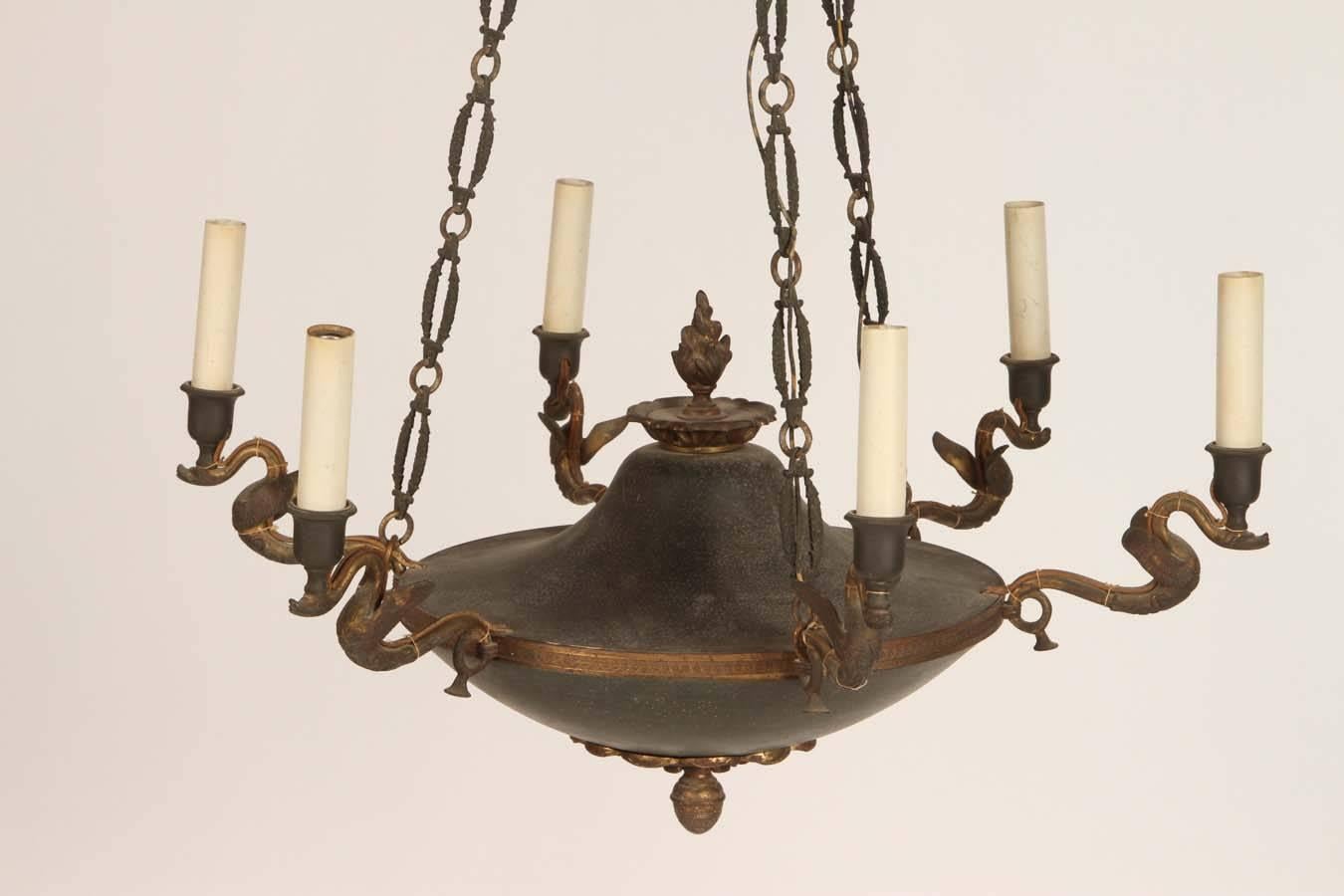 This lovely French Empire style chandelier has six swan arms and a flame finial. Dark green tole painted body. Wonderful original chain and ceiling cap.