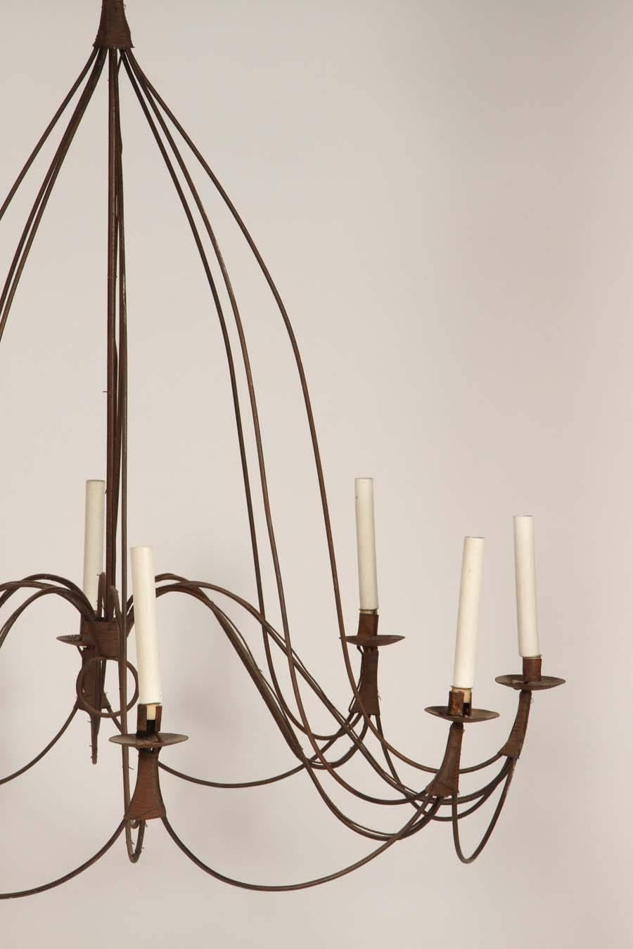 Large French Provincial chandelier with eight-lights. It's delicately simple lines contrast wonderfully with it's rustic material and construction. Perfect in an entryway or on a covered veranda.