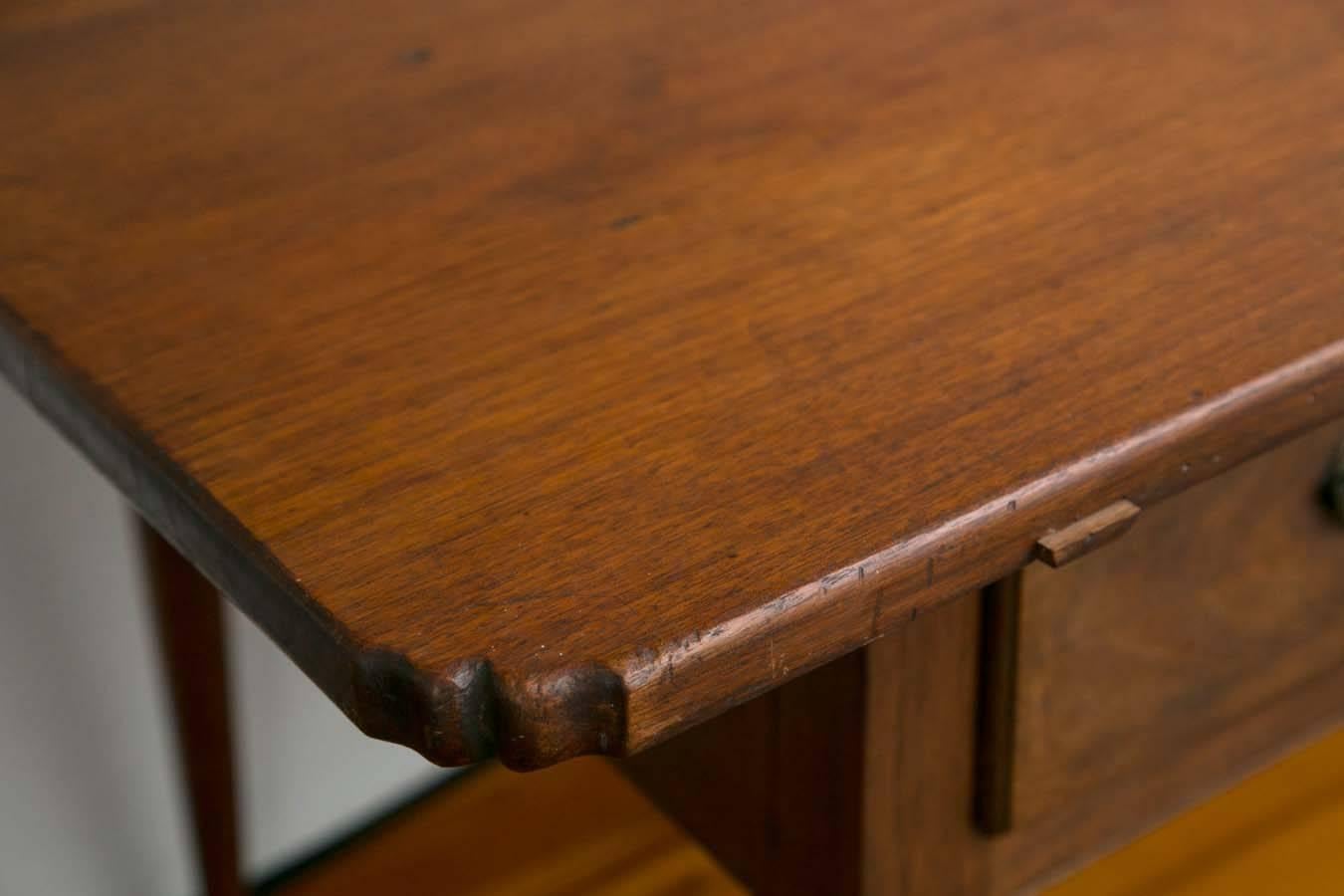Walnut tavern or work table, the rectangular removable pegged two board top with rare notched corners projecting above base with two long overlapping candle drawers flanked by two dovetailed drawers supported on turned tapering legs with pad feet.