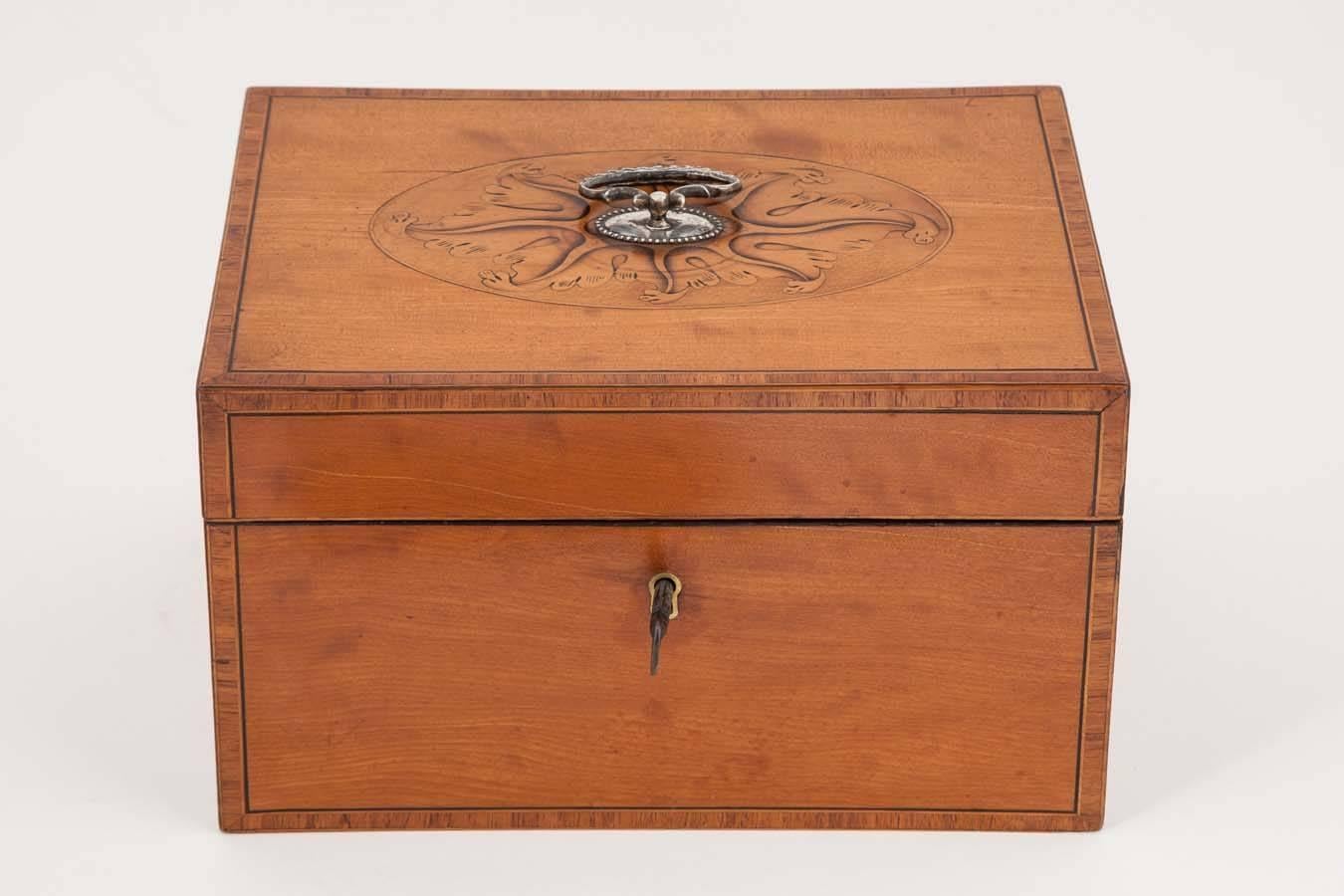 This exceptional example retains its original pair of oval pewter caddies and red velvet lining. The satinwood box with ebony and boxwood stringing and kingwood cross banding, the lid with wonderful patera and silver handle.
 