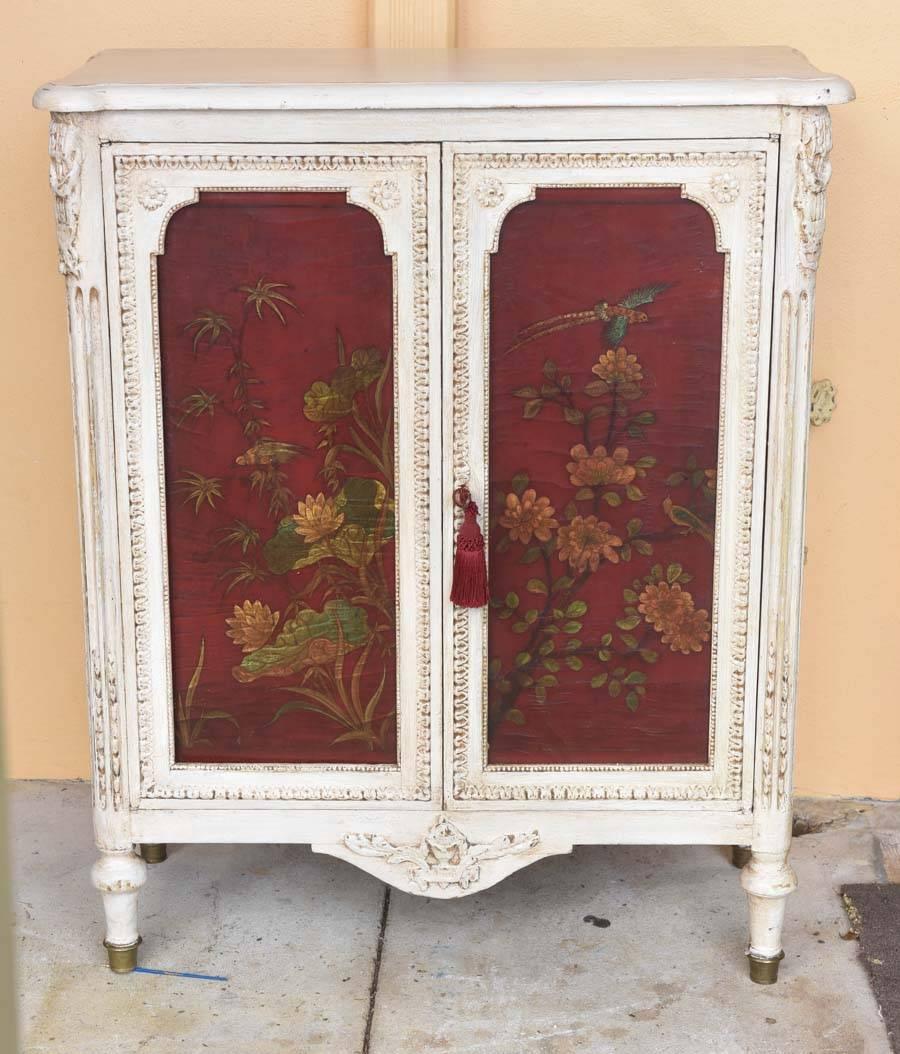 
This is a very nice hand-painted French two-door cupboard.
It sits on turned legs with a brass cup to the bottom, the doors are hand-painted with birds in a deep rich red color.
I think at some time it was yellow and has been later painted