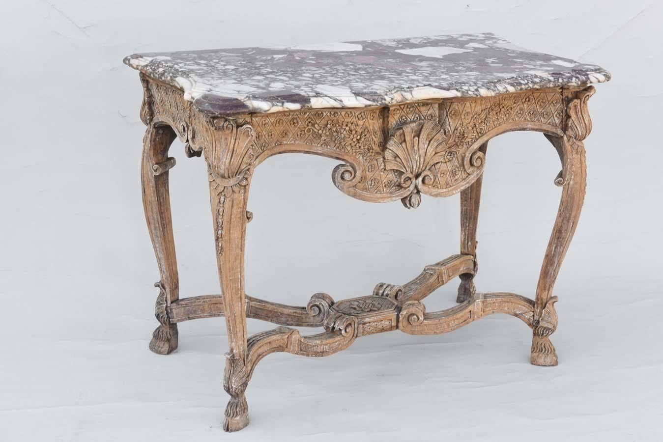 Console table, having a shaped top of rouge marble, on bleached walnut table base, its apron carved with an exaggerated scallop shell, and C-scrolls, against a cross-hatch background, raised on foliate-headed cabriole legs, joined by serpentine,
