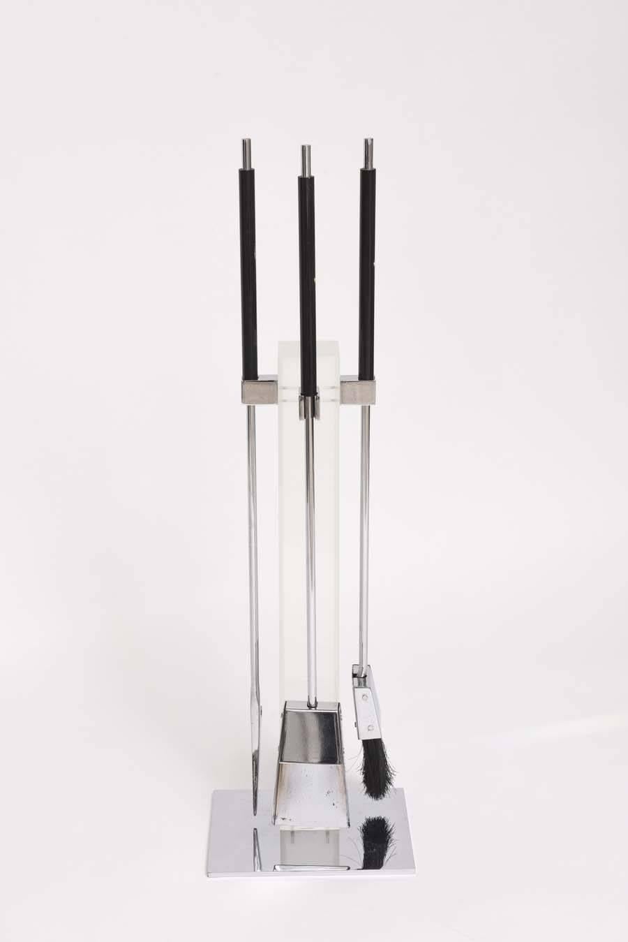 This handsome fire-tool set is in the style of pieces created by Danny Alessandro of NYC in the 1980s. The set is in polished chrome with black Lucite handles and consists of a log-poker, shovel and broom. 

For best net trade price or additional