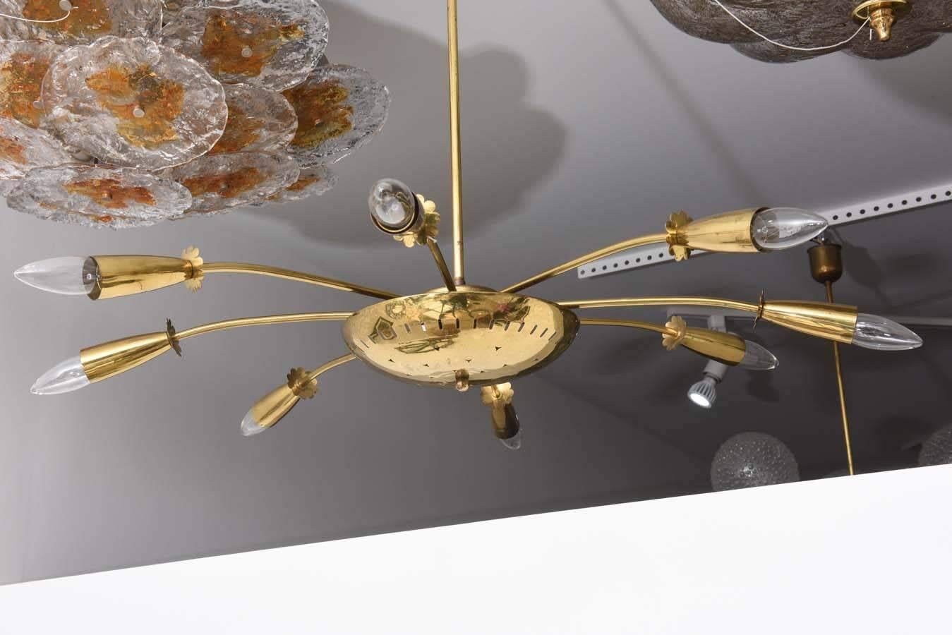 This cosmic inspired chandelier was created in the 1950s in the style of the iconic Italian firm of Stilnovo. The eight-arm design is very representative of a bursting star or comet.

Note: This piece requires eight European based candelabra