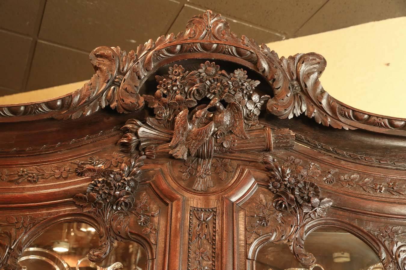 French display cabinet with carvings of love birds.
It has three glass shelves that have been added as well,
as mirrored back and mirror on the bottom. The shelves
are adjustable. The cabinet is made of oak and dates to
Late 19th century, it has