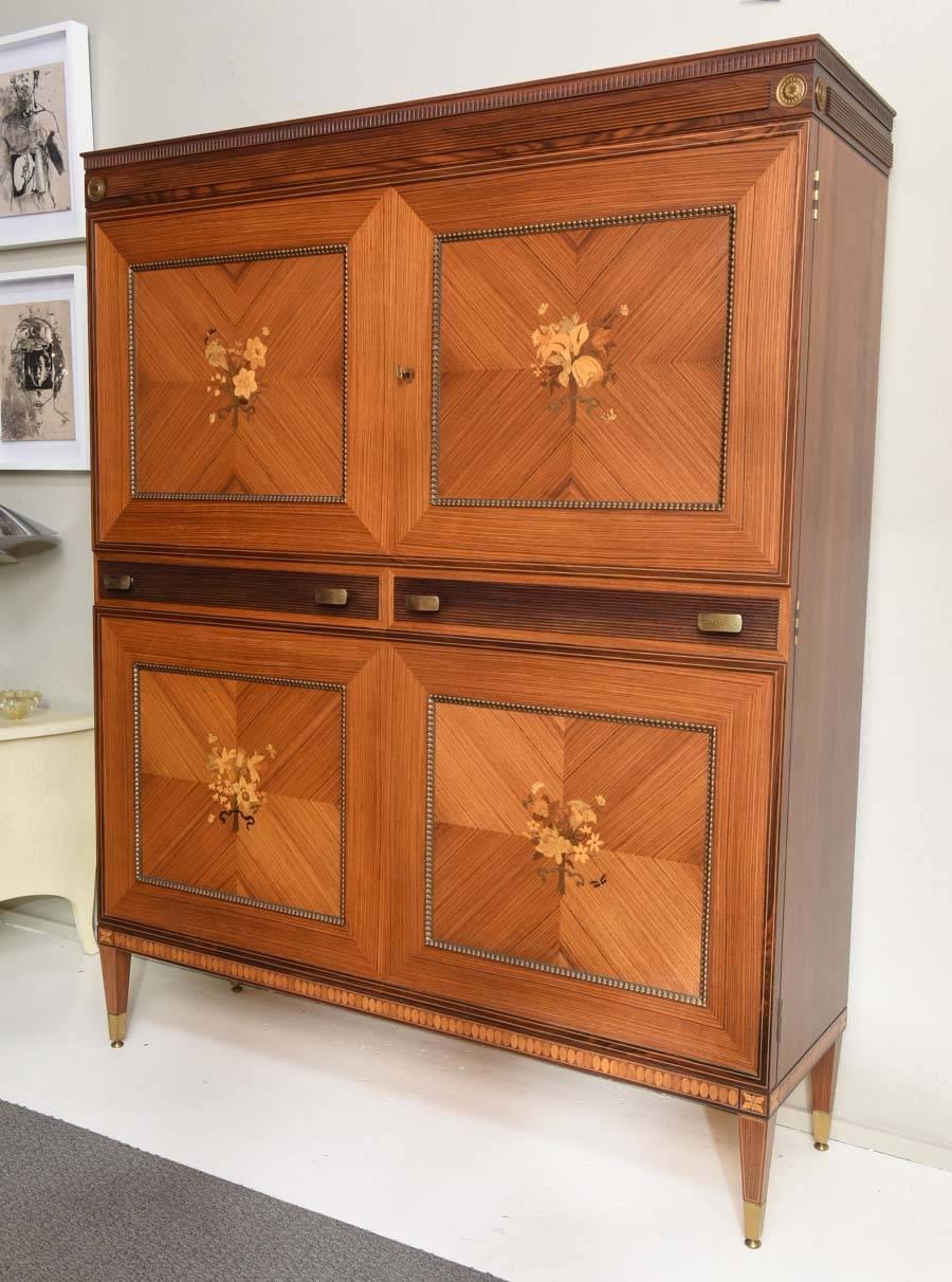 Stunning large Italian bar cabinet attributed to Paolo Buffa. Impressive exotic woods marquetry and brass details, with lighted and mirrored interior with extensive storage. Manufactured circa 1950 by La Permanente Mobili Cantu, the exquisite