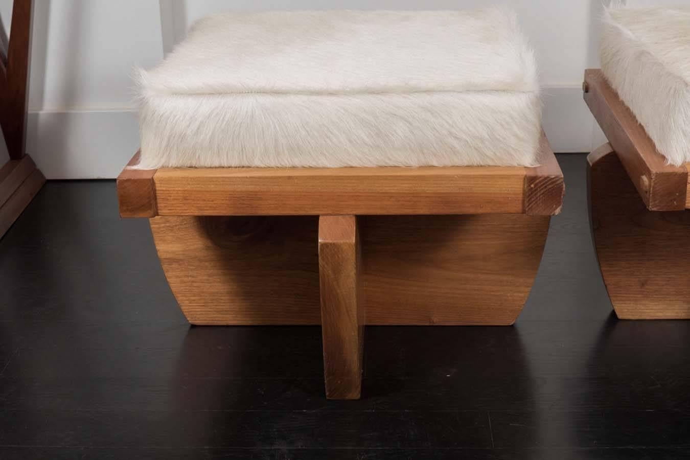 Pair of oak benches with cowhide upholstered seats.