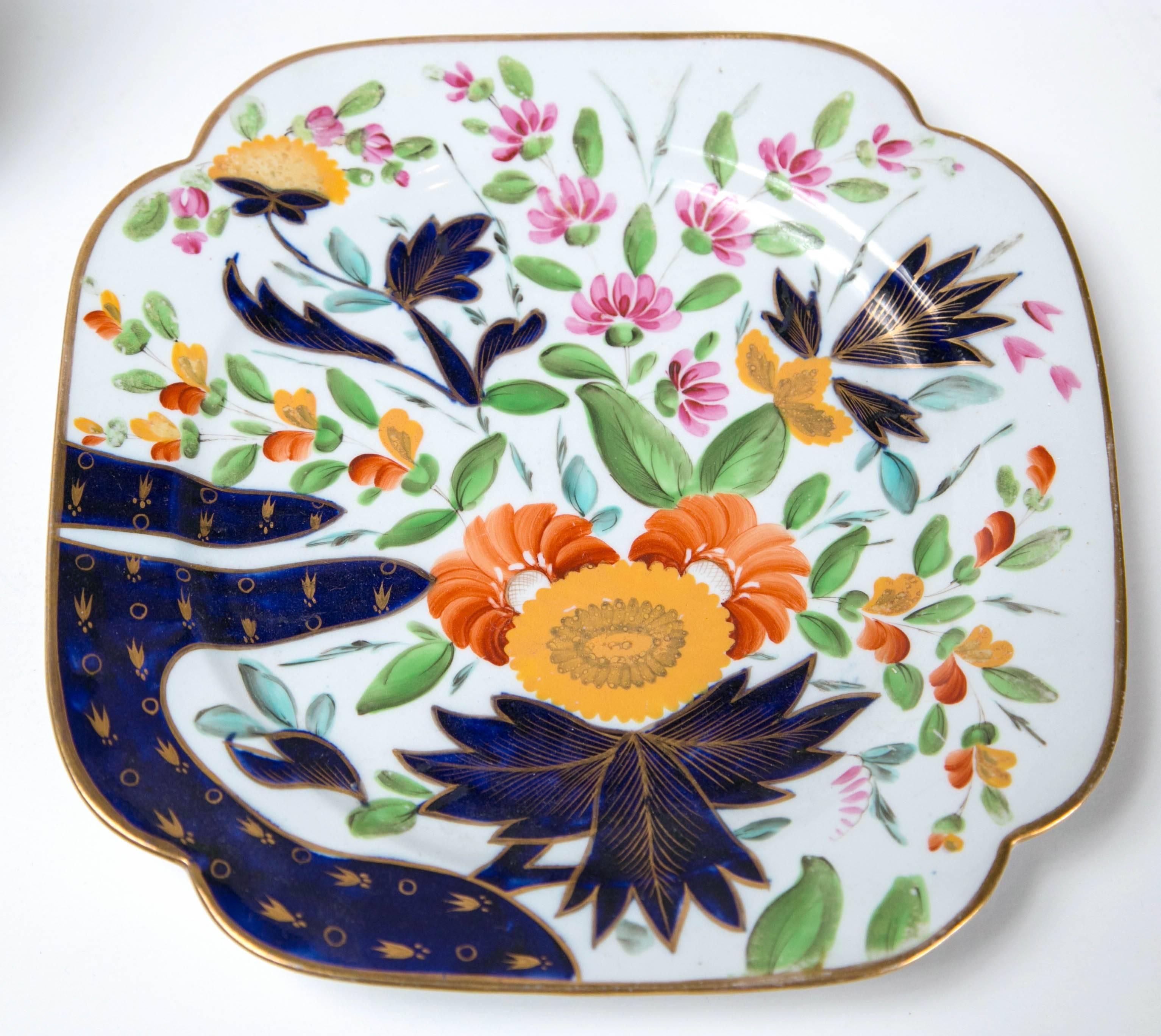 A pair of coalport square dishes in a floral pattern with gilded accents and curved 
edges.