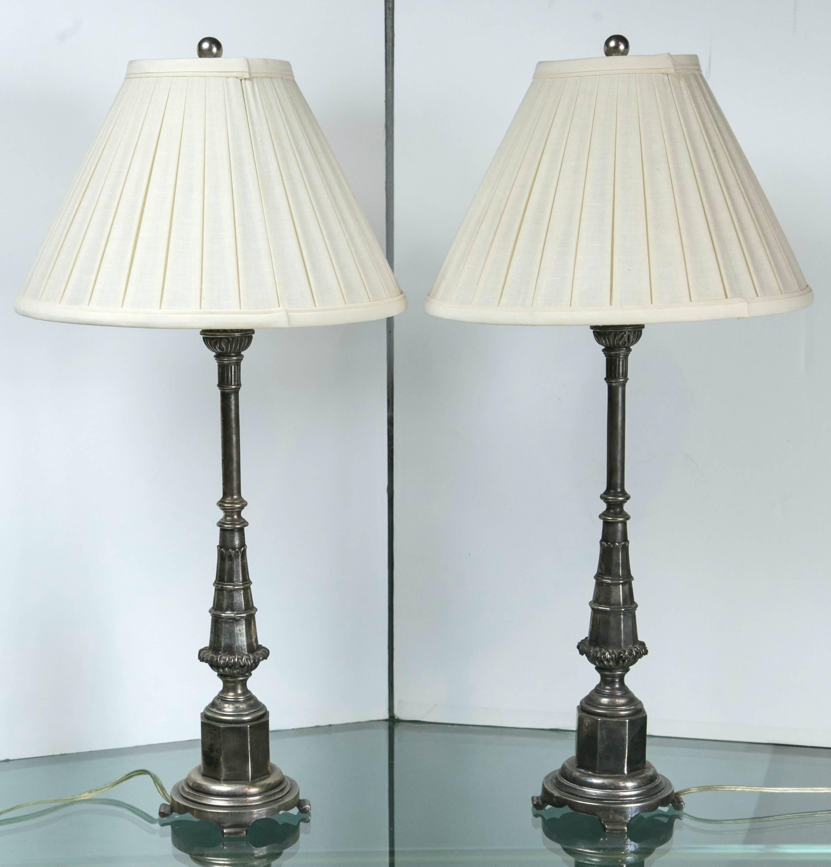 A pair of unusual and decorative lamps with octagonal base and tapering shaft. Cast in silvered brass.