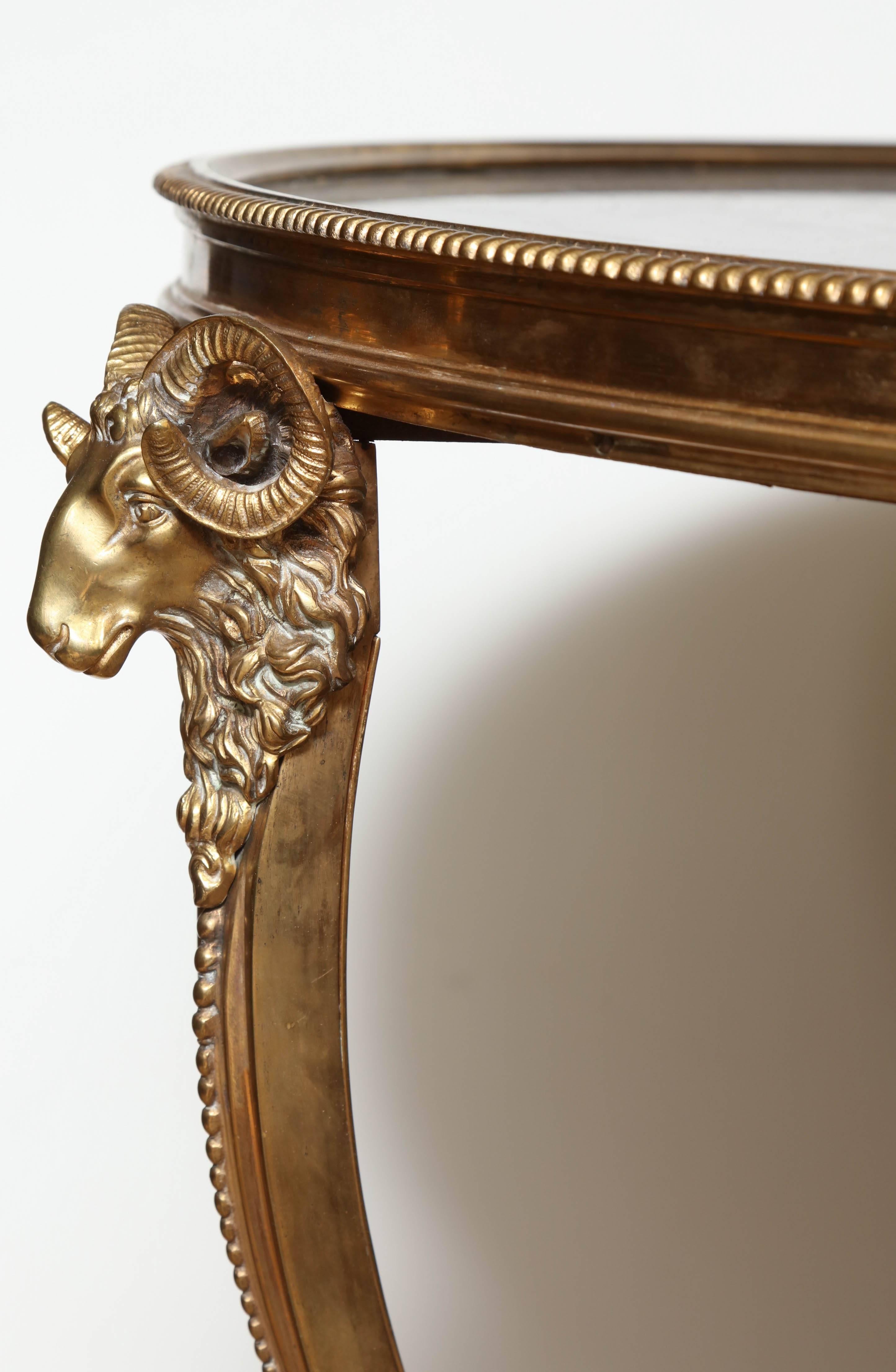 Fine pair of French Louis XVI style gilt bronze and marble top two-tier gueridons with ram's heads and hoof feet.