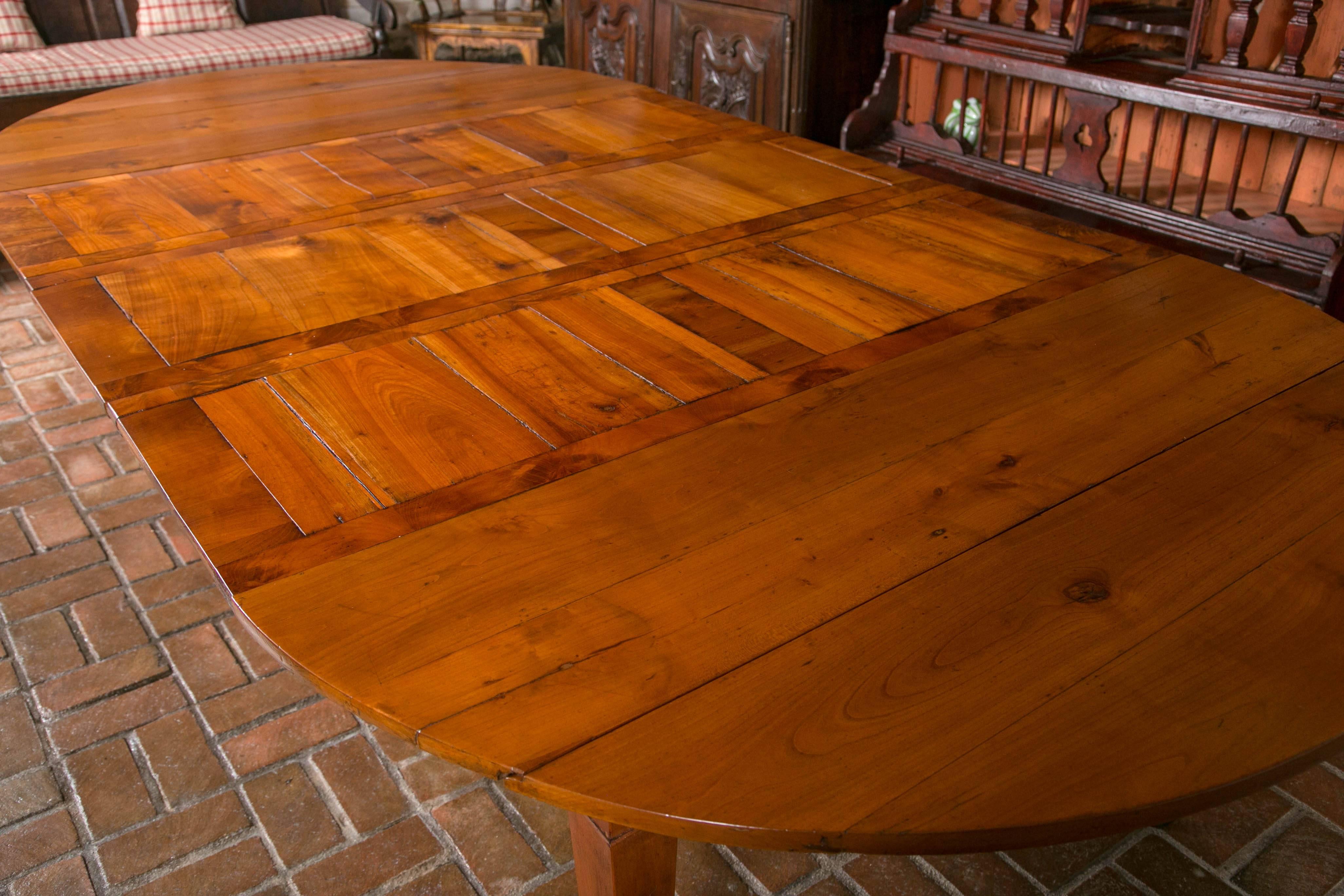 An enterprising person a long time ago decided not to hide the fact he was creating an extension table by incorporating shutter style leaves and telescoping support frame. The result is an unique adaptation of a French cherry drop leaf table with a