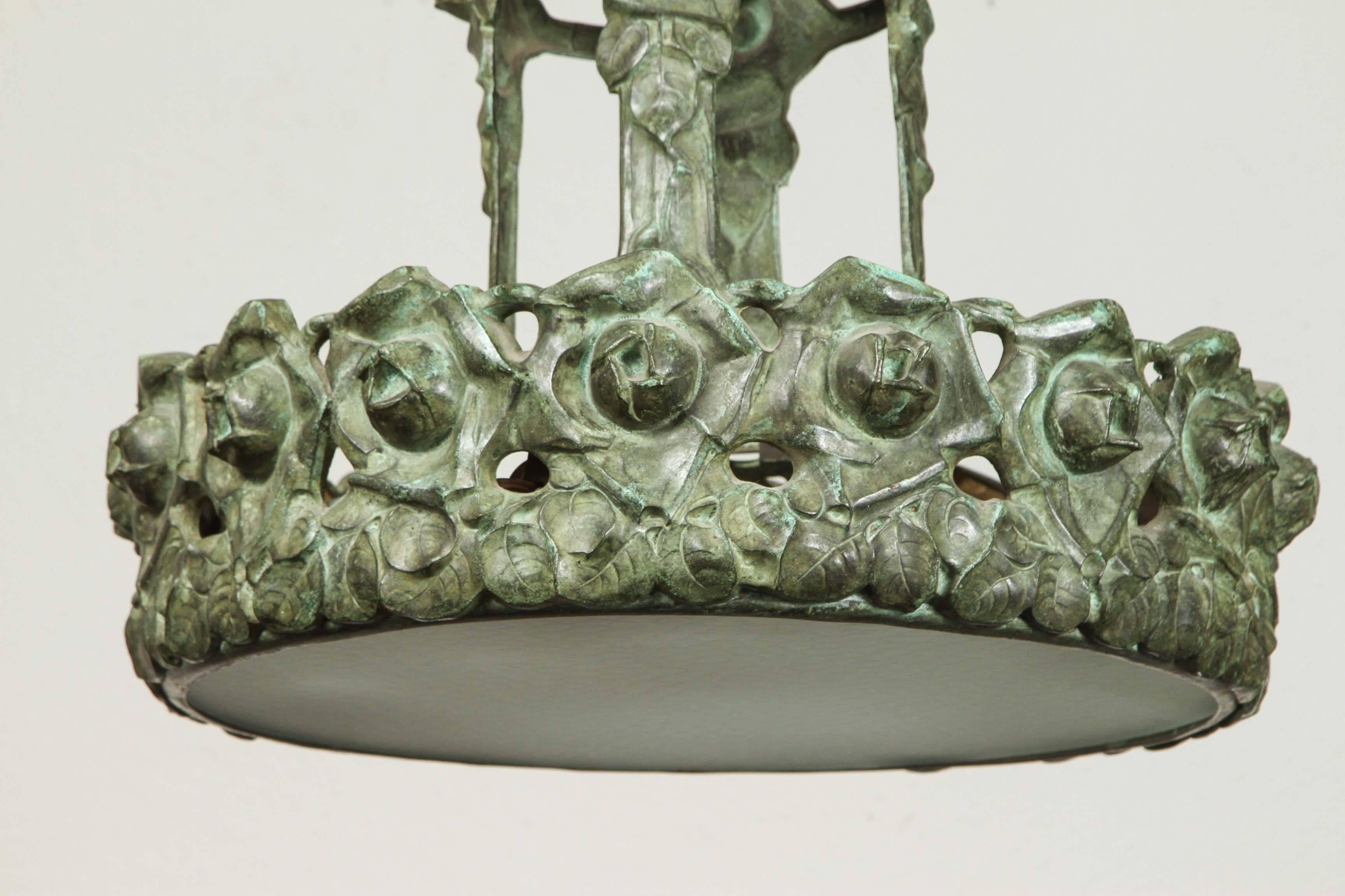 Hand-cast bronze and frosted glass, French chandelier featuring a circlet of roses and leaves. The whole surmounted by a pierced dome.