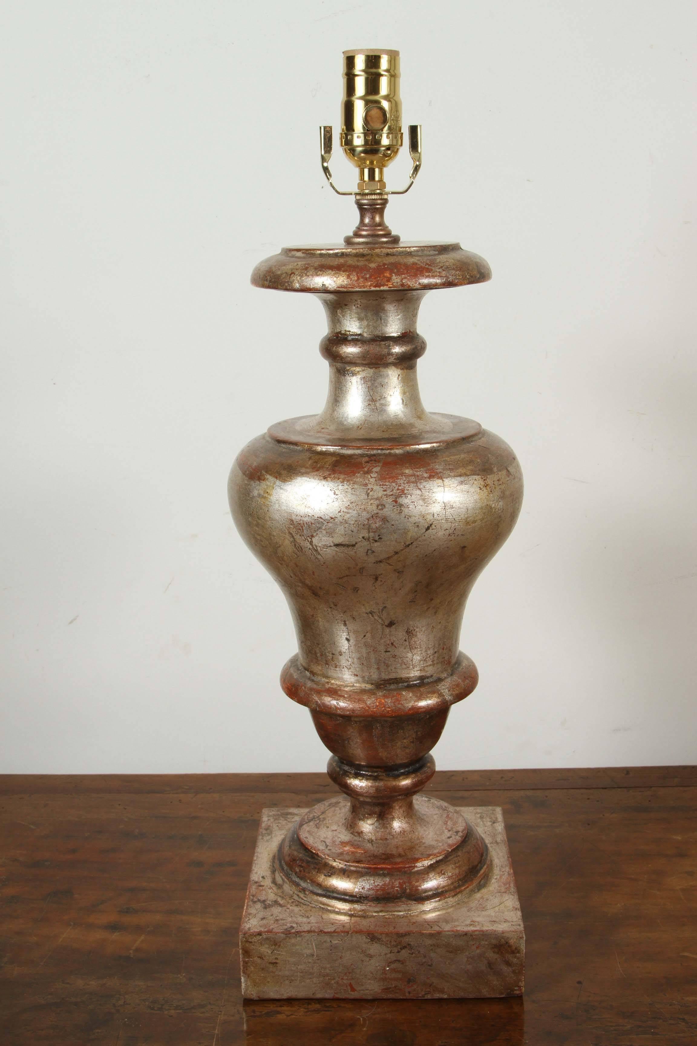 Paire de lampes de table en bois sculpté, dorées à l'argent, en forme d'urne, d'Italie.