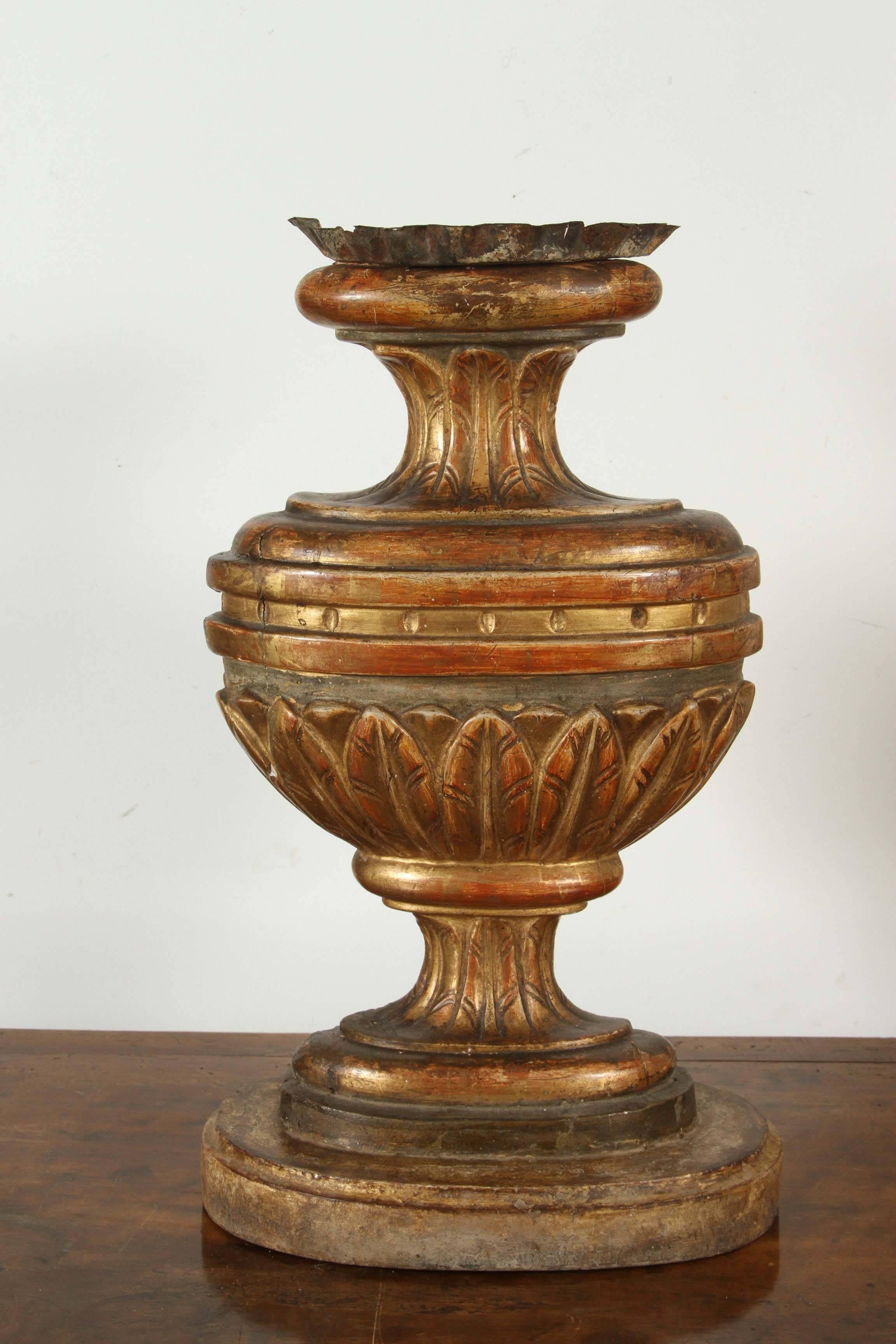 Pair of carved, hand-painted, gessoed and gold gilded, oval candlesticks with acanthus leaf details.