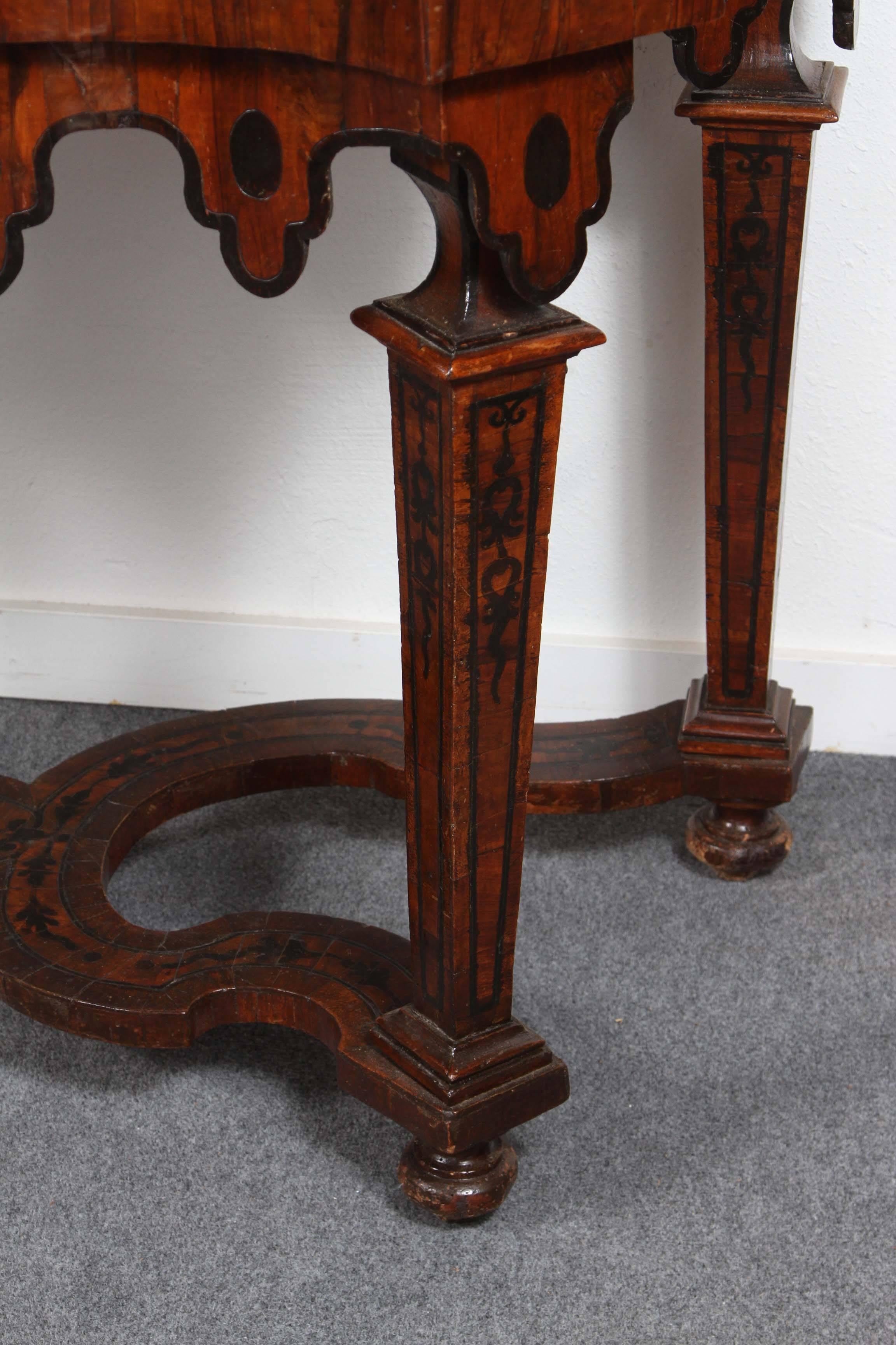 Richly carved, veneered and inlaid, serpentine, Burl and Ebony console with pronounced, scalloped apron and stretcher. 