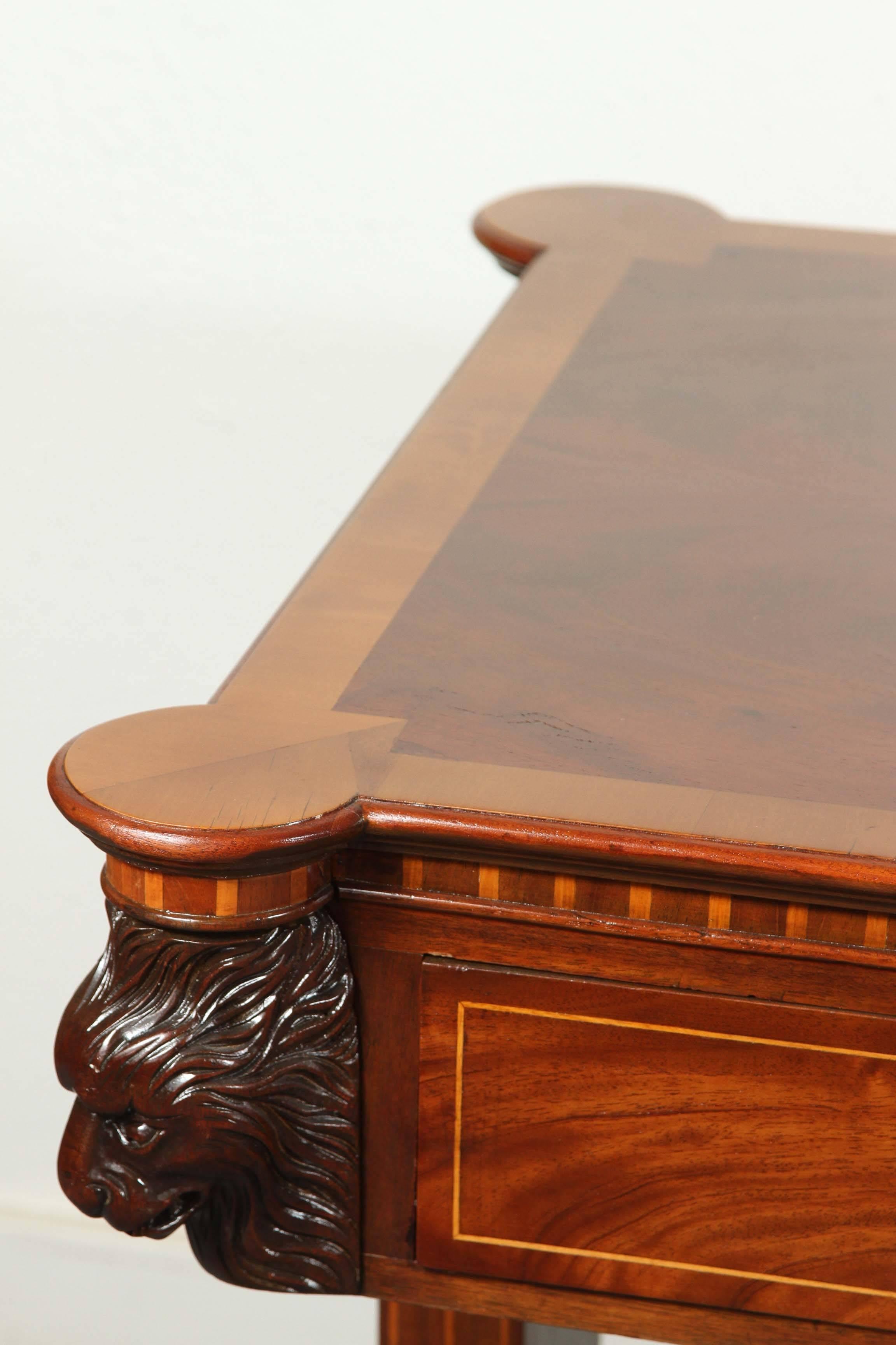 Hand-carved, veneered and inlaid, four-drawer, Florentine, walnut partners desk. Each corner is embellished with wonderfully carved lions heads. The whole above an elegant stretcher on paw feet. 