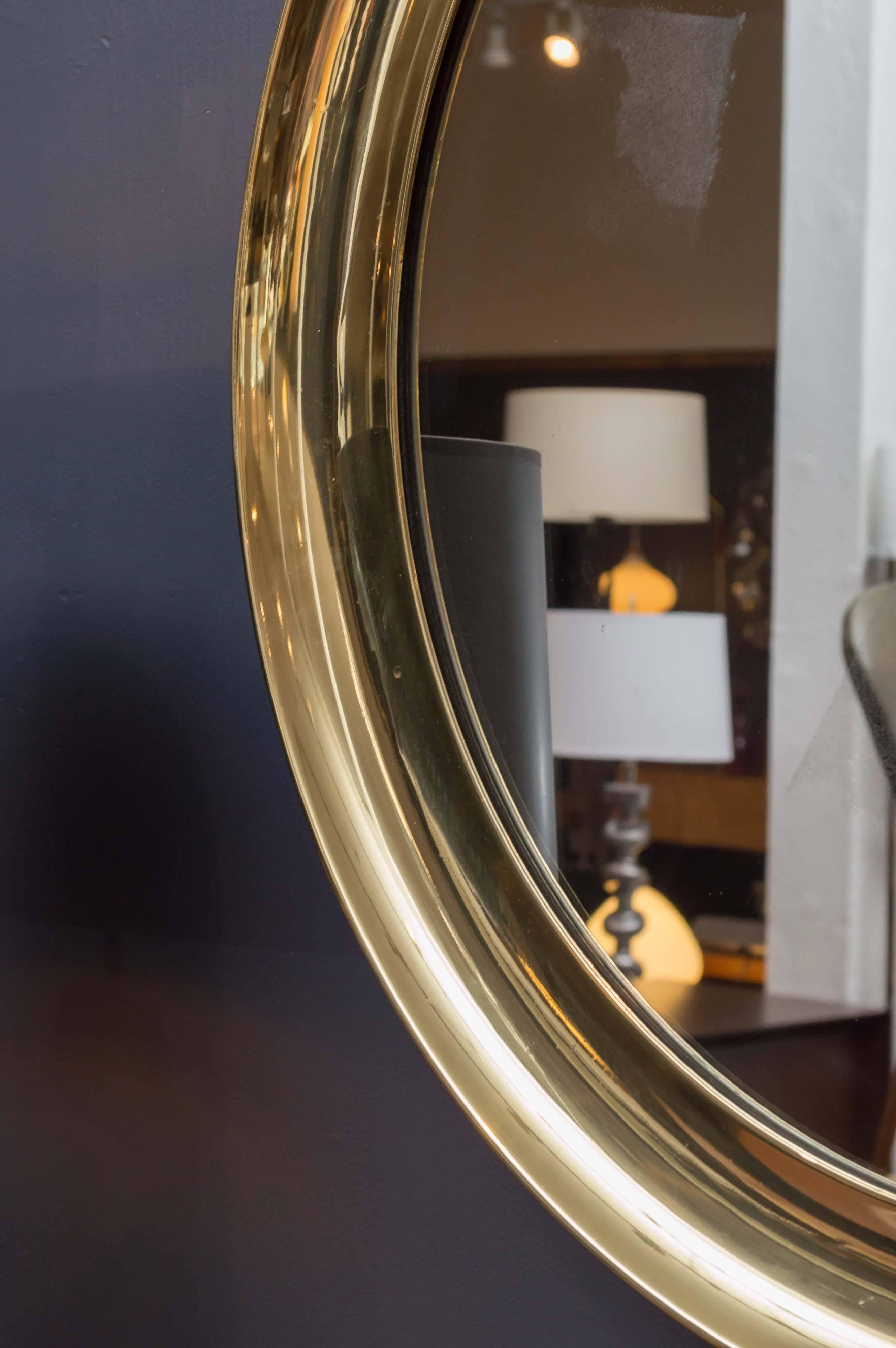 Large Italian brass port hole wall mirror, concave frame has been professionally polished. Original mirror plate has slight oxidation but not distracting and can be easily replaced.