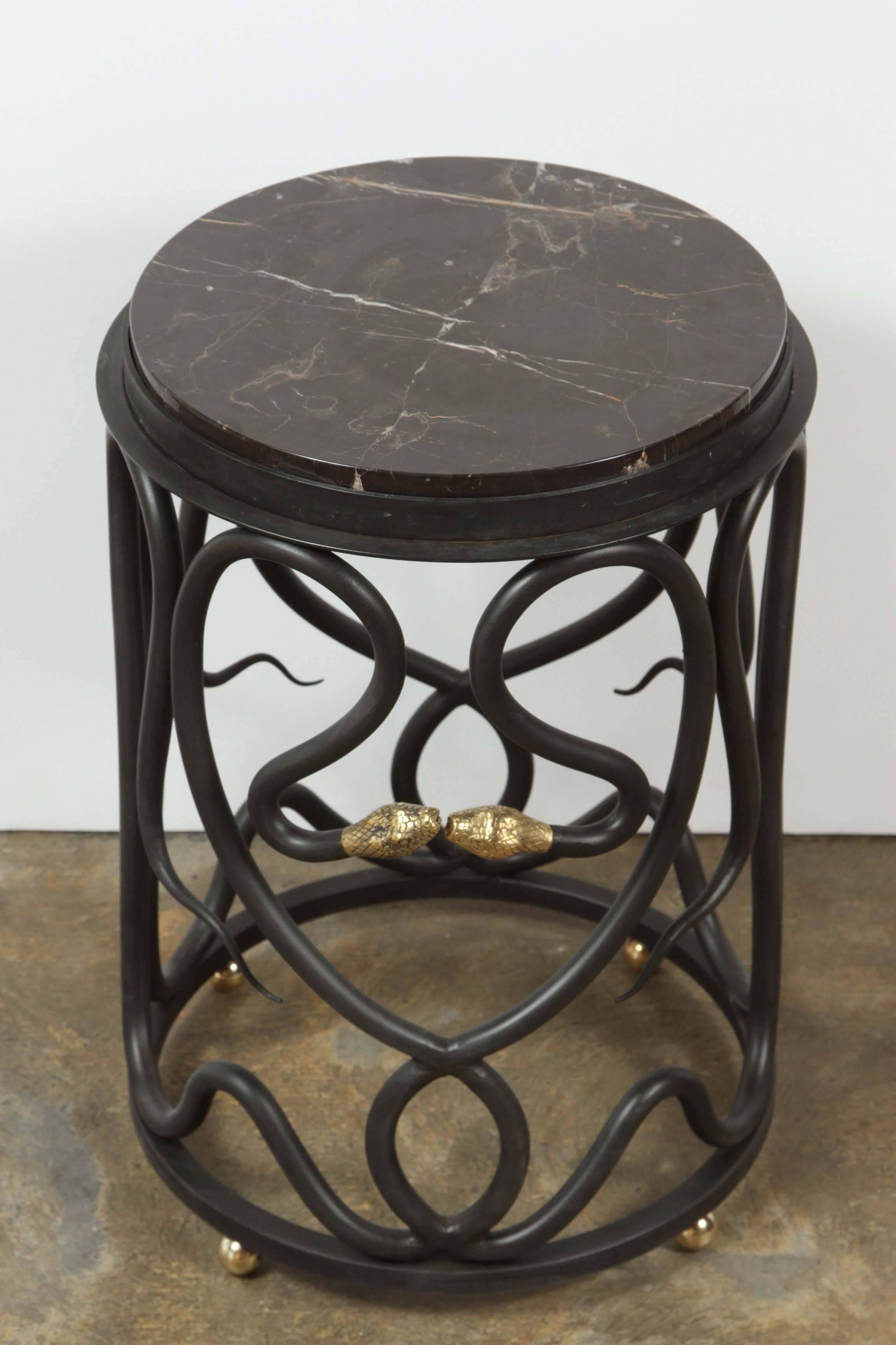 Paul Marra snake table. Steel table in bronze patina with brass snake heads and brass table feet. Polished marble top is Noir St. Laurent. Currently one in stock, price is per table.