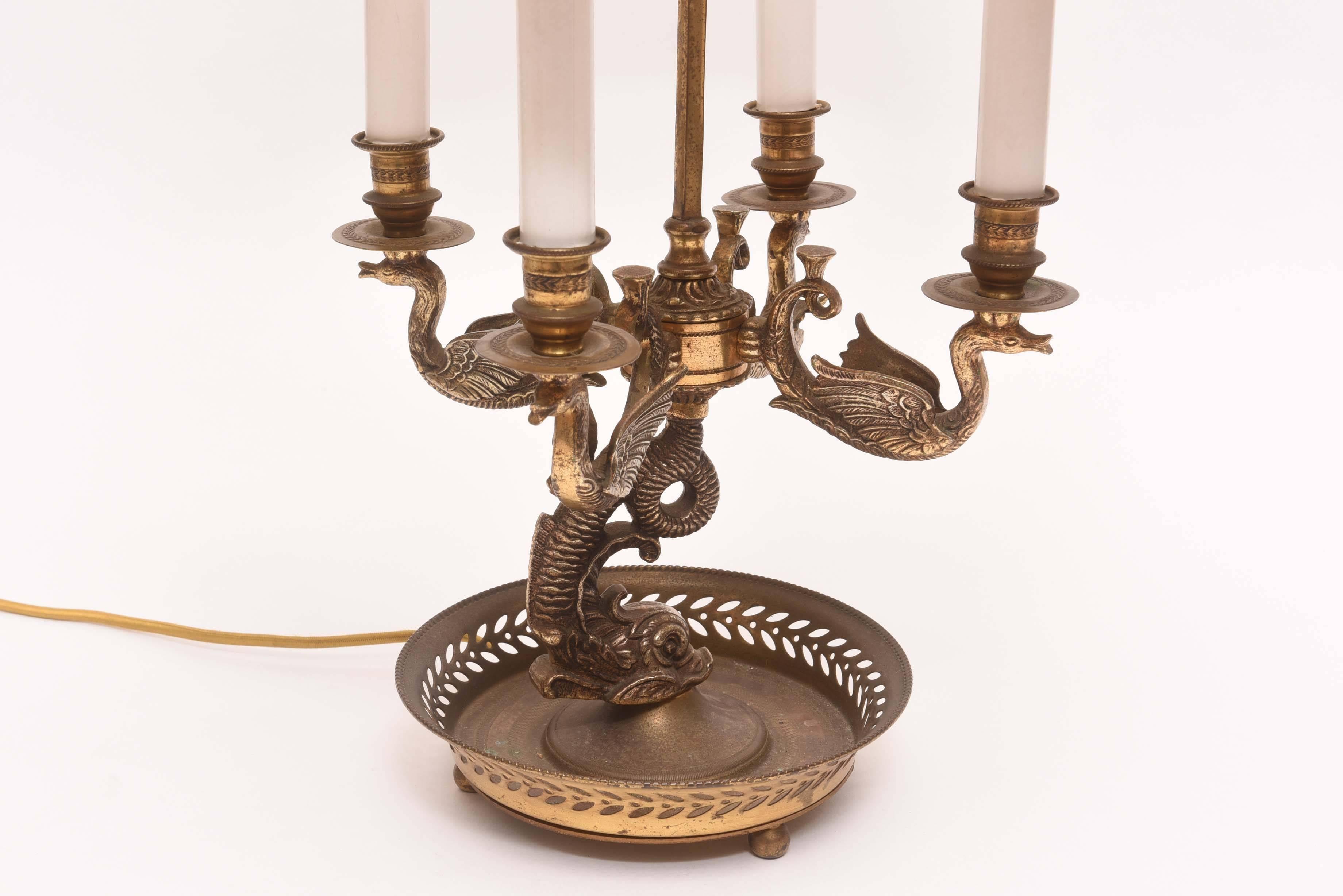 Large and regal pair of late 19th century Bouillotte lamps with dolphin base and swan arms. Finished at top with beautiful bronze dolphin finial. Original dark hunter green shades with gold design.