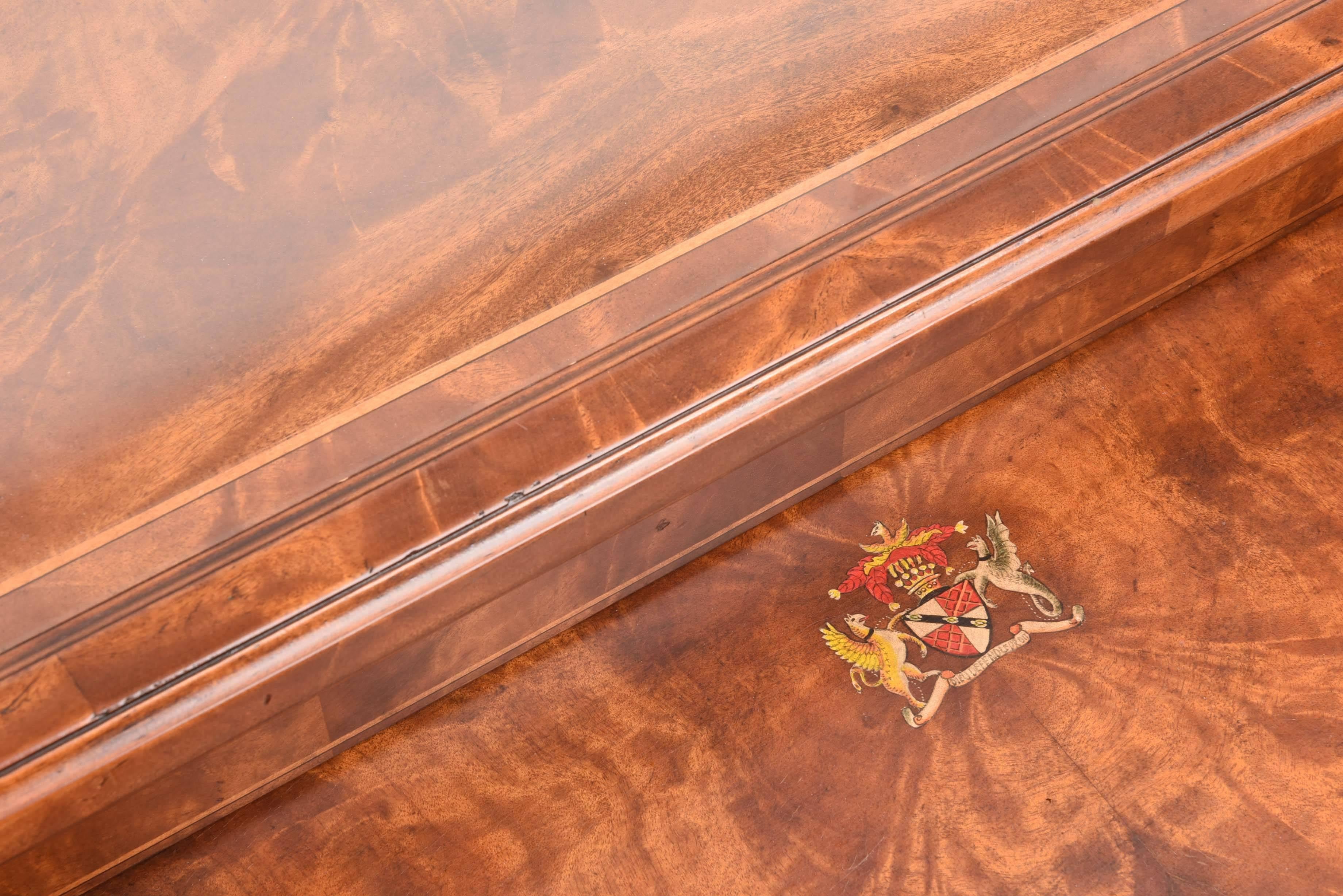 Auffällige Nisttische im neoklassischen Stil mit abnehmbarer Glasplatte von Theodore Alexander. Griffe, Füße und Zierleisten aus ziselierter Bronze. Wappenmotiv auf kleinerem Tisch. Eine wunderbare Ergänzung für jeden Wohnbereich.