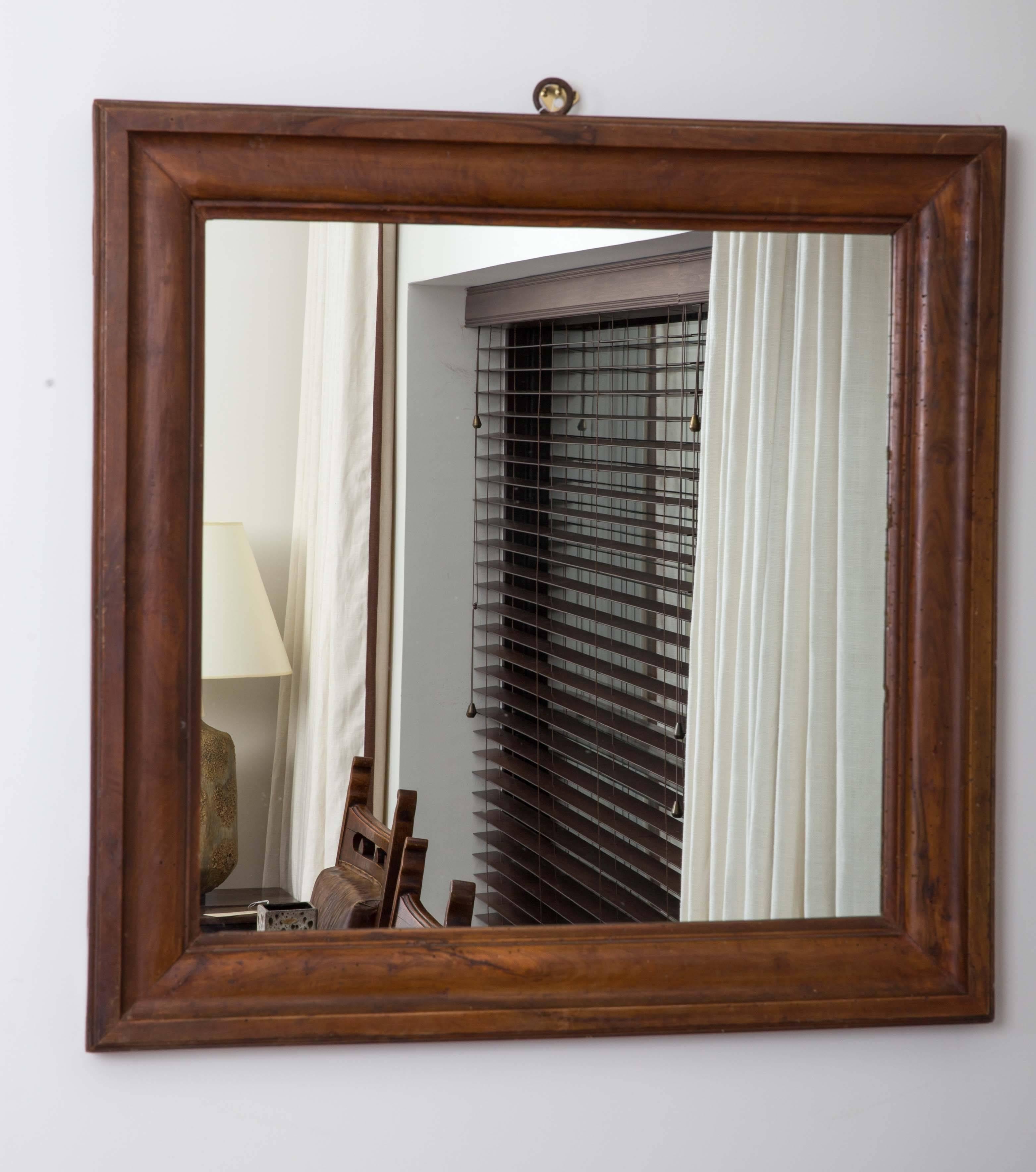 Walnut framed mirror, with metal hook on top.