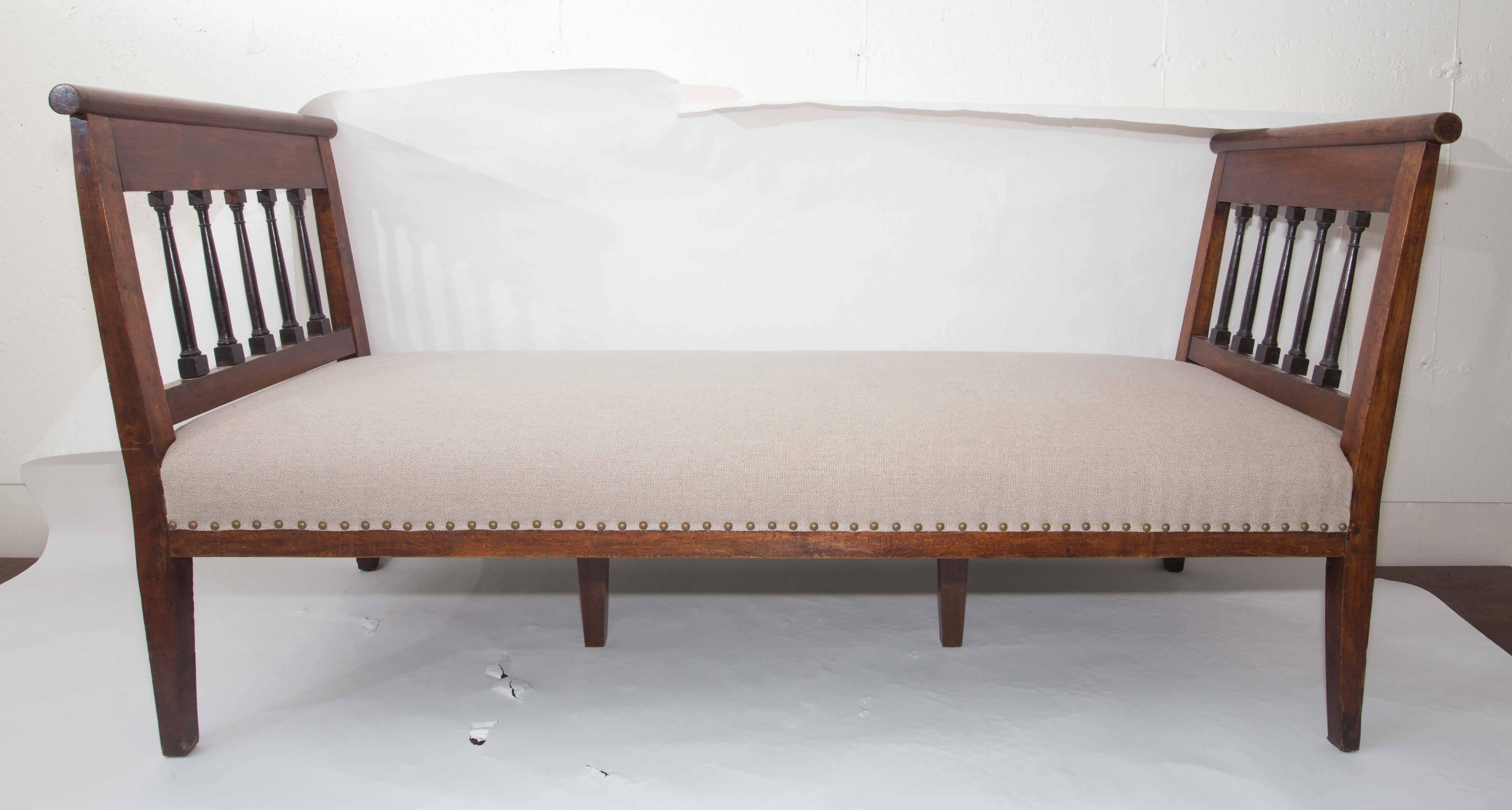 Large walnut bench with upholstered linen seat.