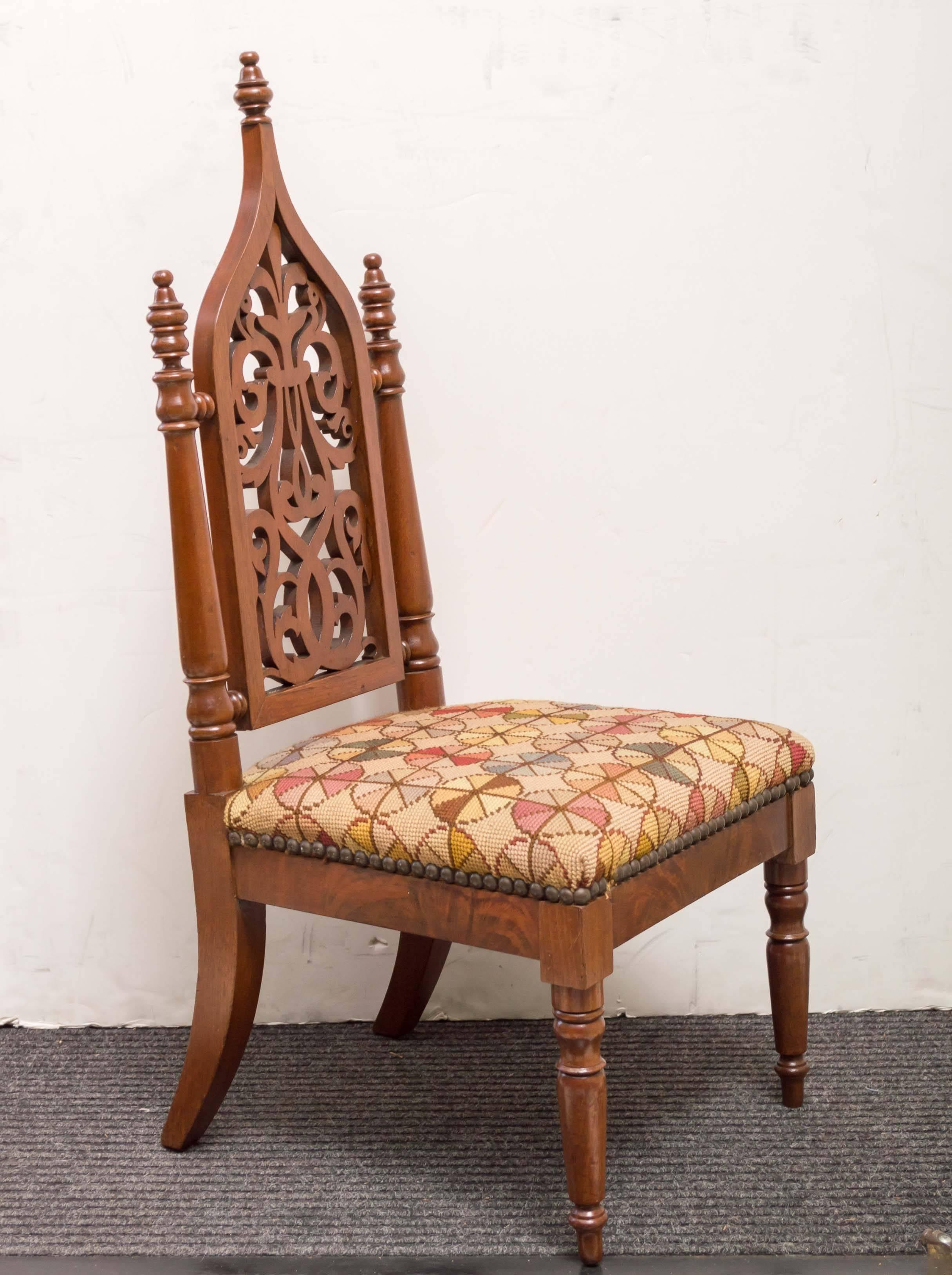 19th century American Neo-Gothic childs chair, circa 1860. Great as a decorative object or use as a taboret. Fine detail woodwork and hand-stitched needlepoint cover. An old surface of mellow walnut.