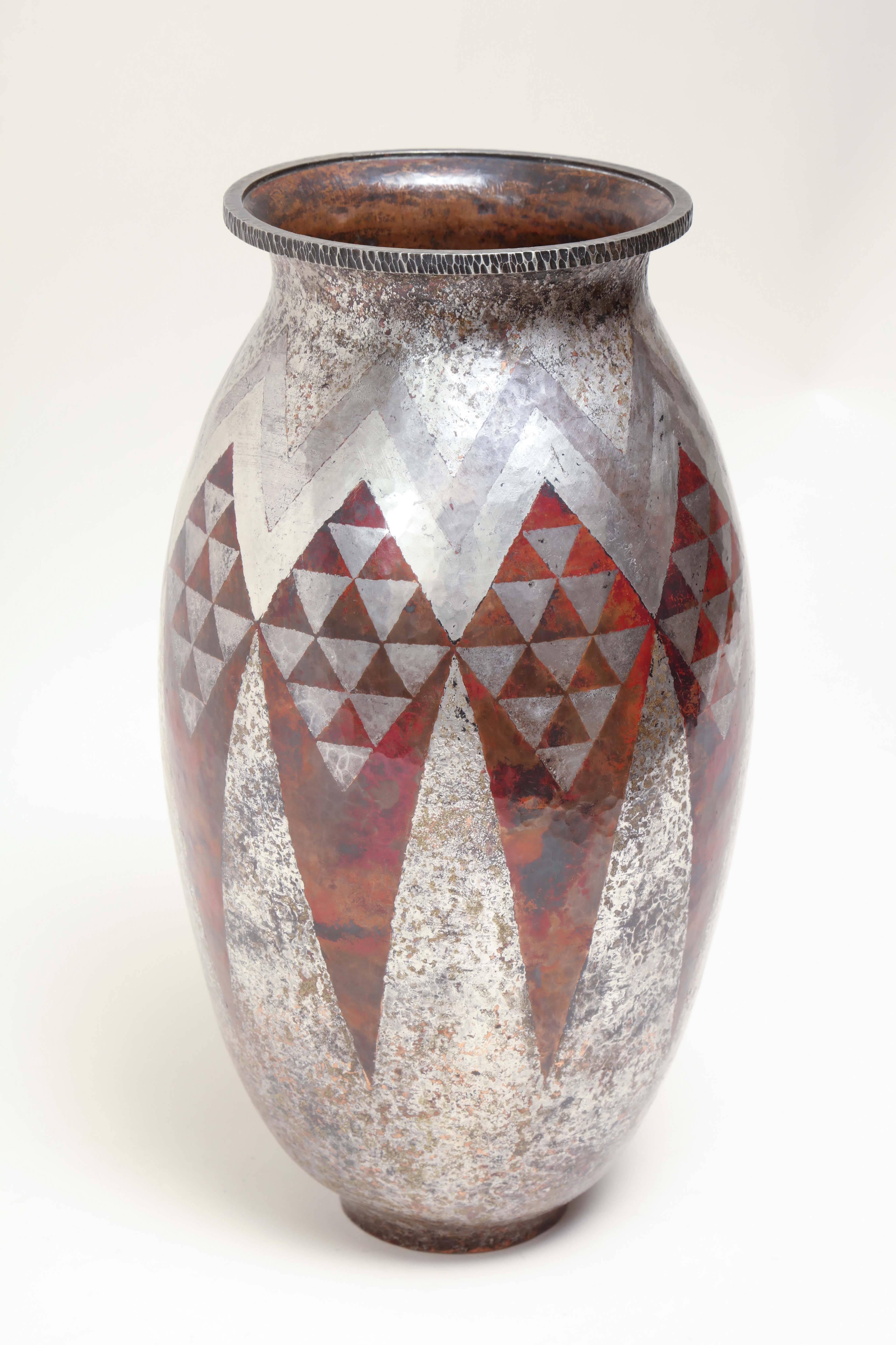 Copper and silver ovoid vase with a geometric design of triangles in red and silver.

Inscribed Cl Linossier underneath.
 